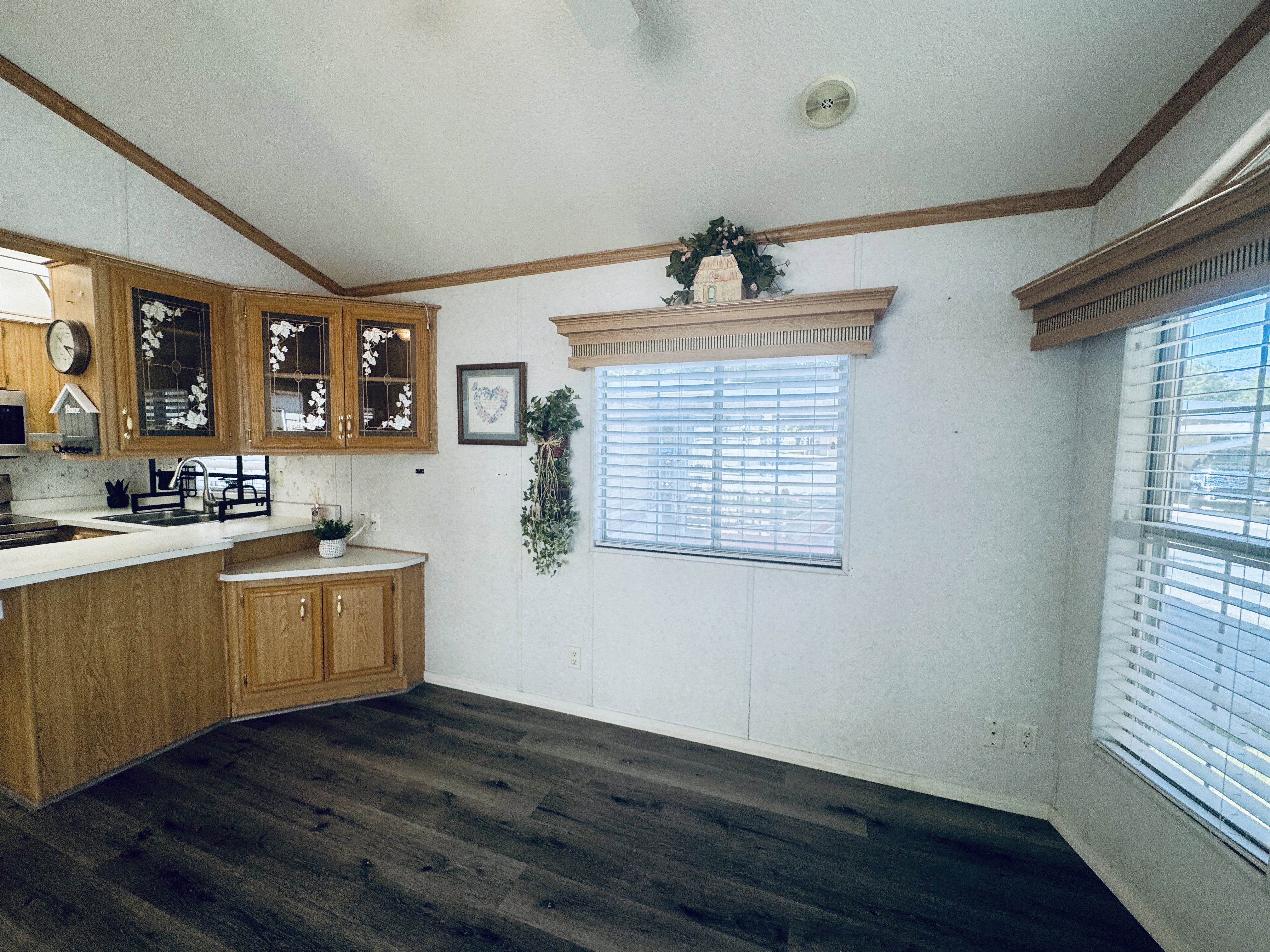 Kitchen featuring wood-finish cabinetry, white countertops, and dark wood-finish flooring