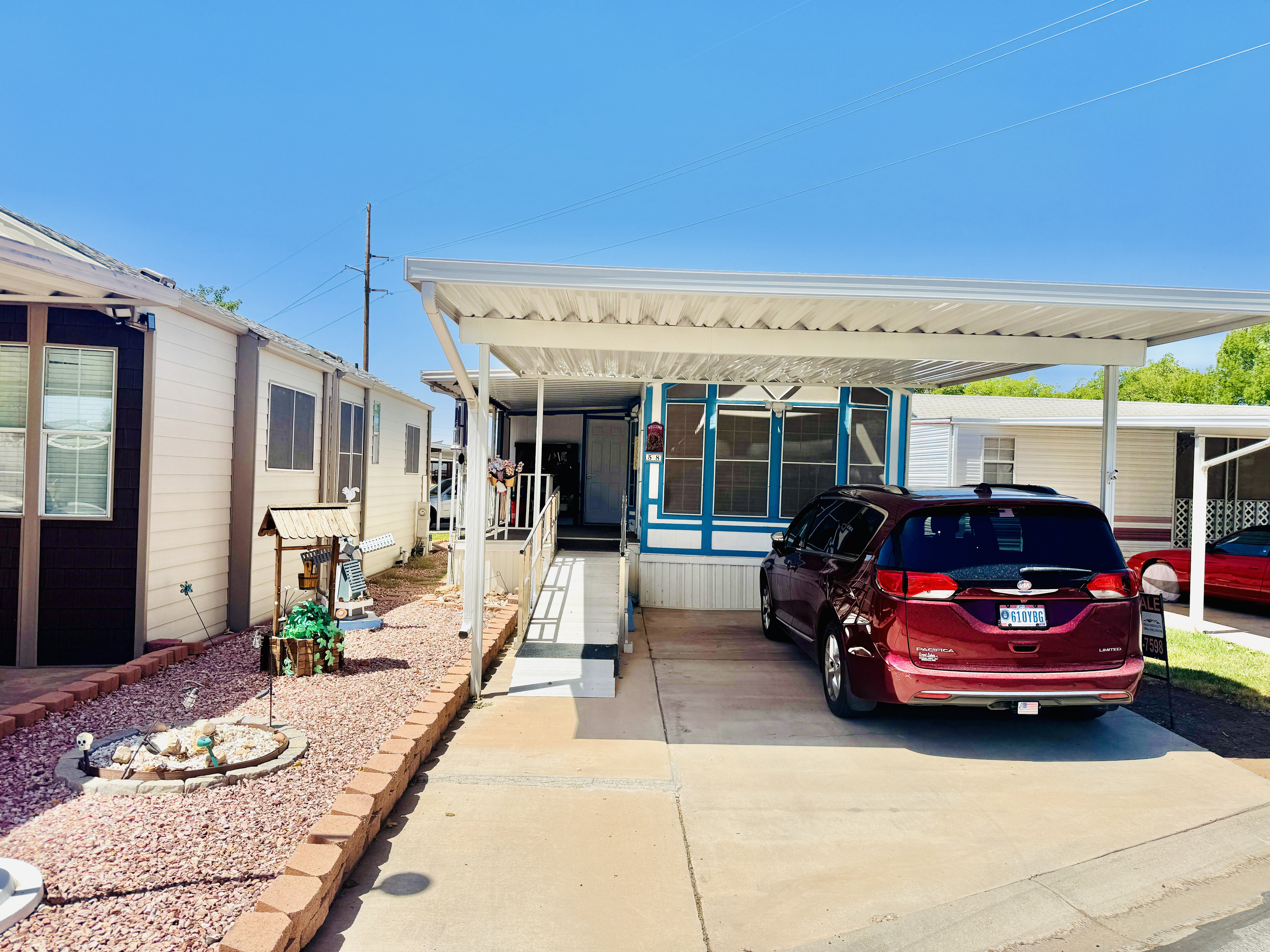 Exterior featuring a covered carport, concrete driveway, and a front entry ramp