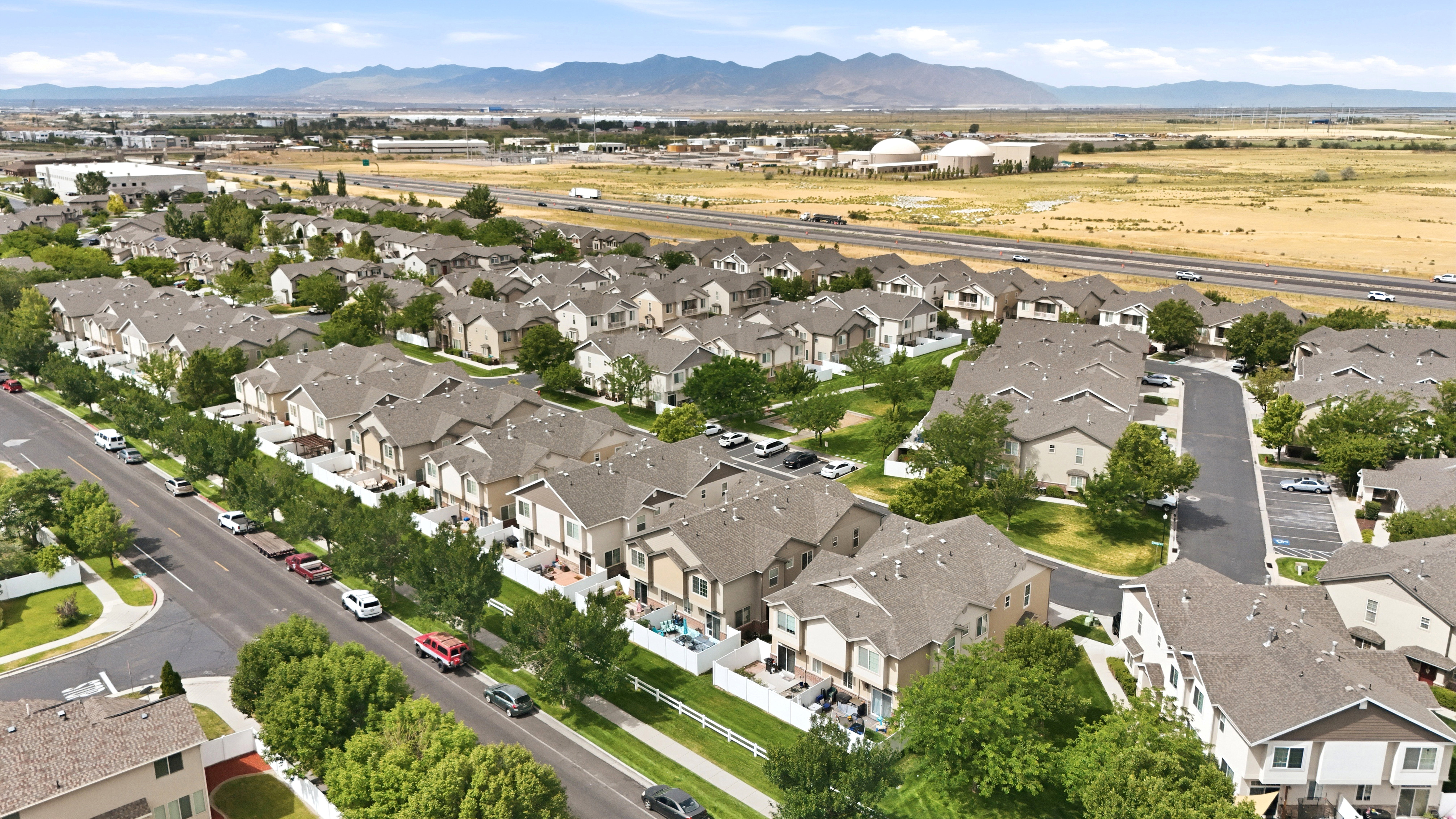 Townhome community featuring neutral-toned exteriors with dark shingled roofs