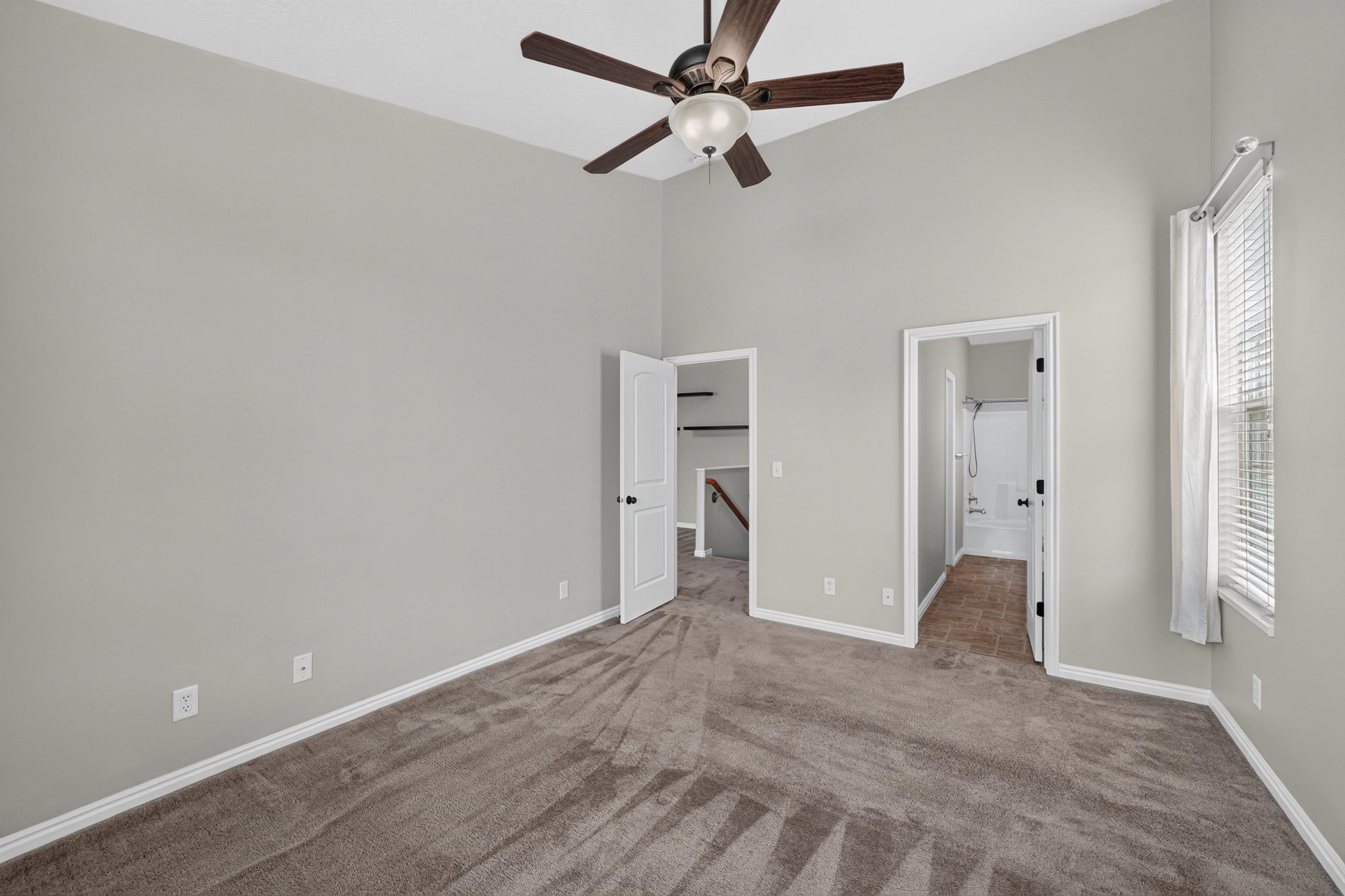 Bedroom featuring vaulted ceiling with ceiling fan, carpeted flooring, and a window with blinds