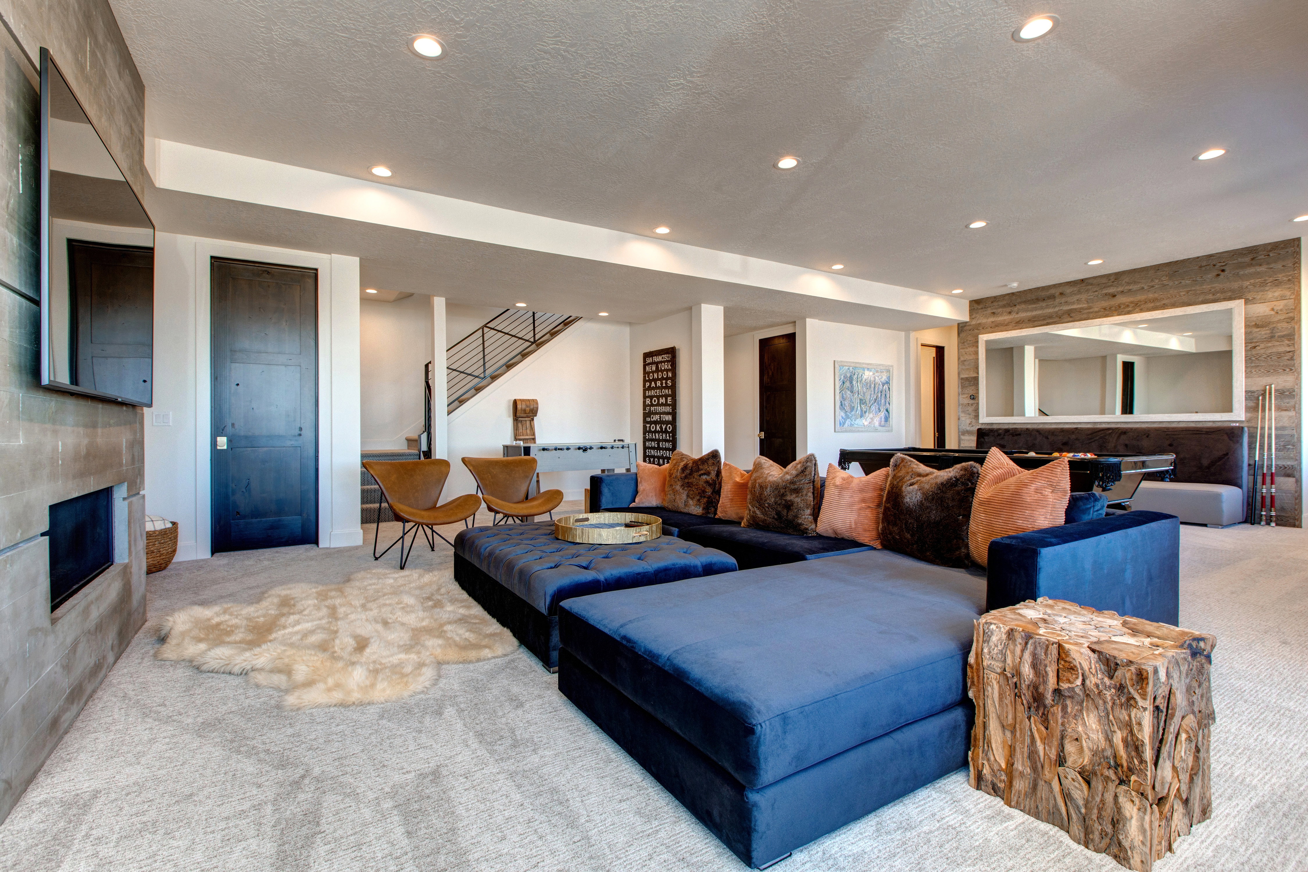 Spacious recreational room featuring recessed lighting, a stone-finish fireplace, and a textured accent wall