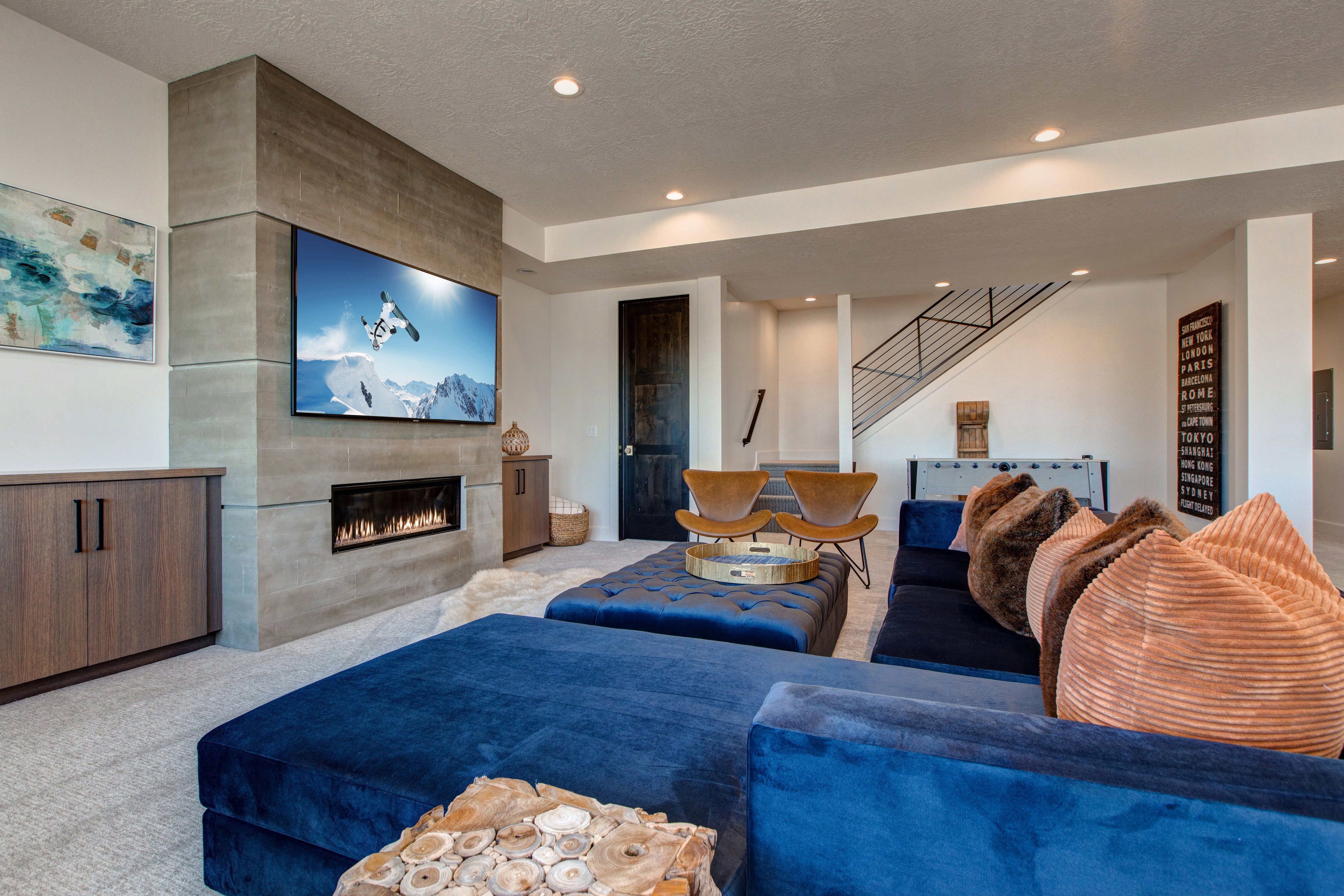 Media room featuring a wall-mounted television above an integrated linear fireplace, a built-in wood-finish cabinet, recessed lighting, and carpet flooring