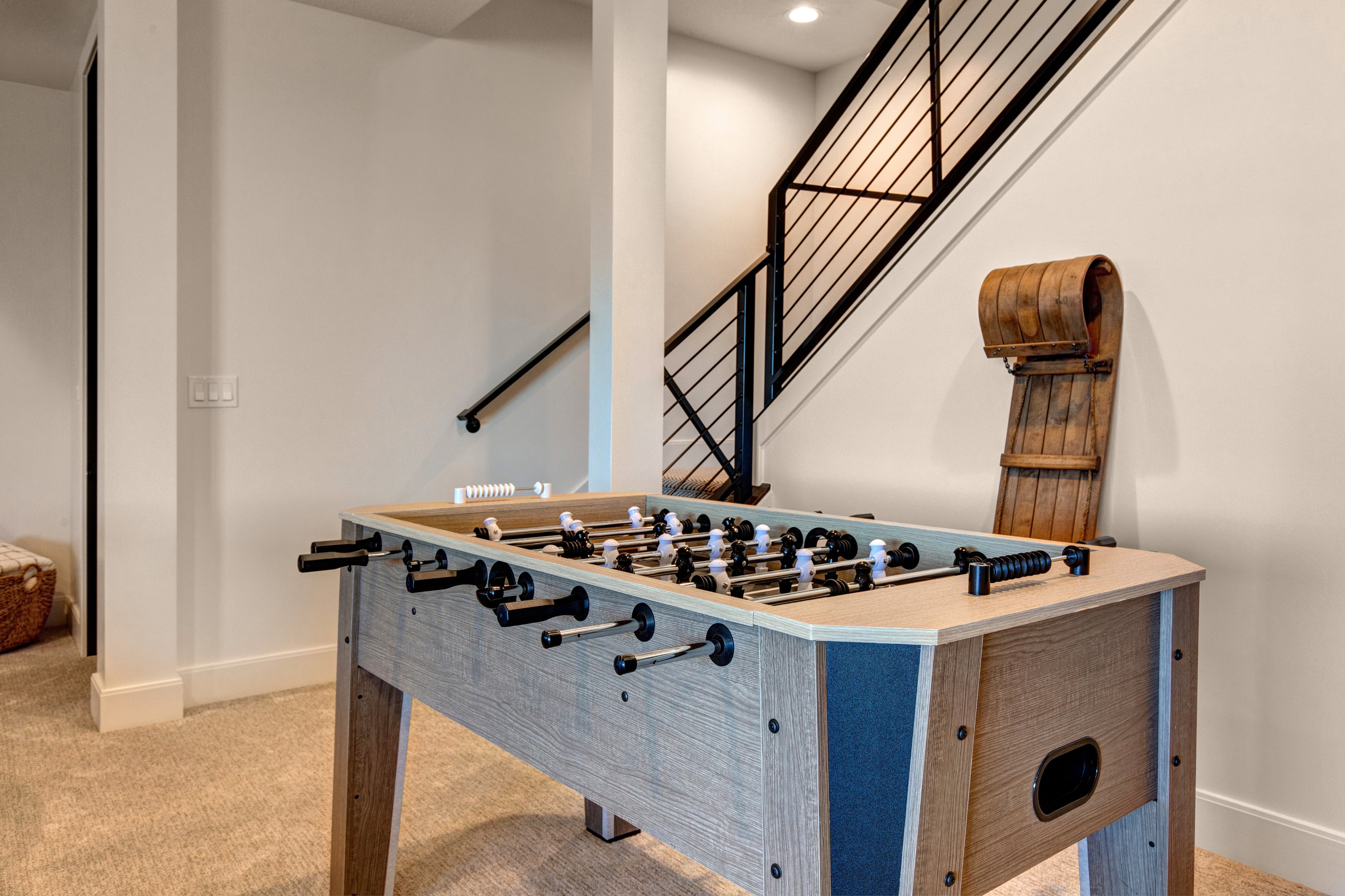 Carpeted recreational space featuring light-toned walls, recessed lighting, and white baseboards