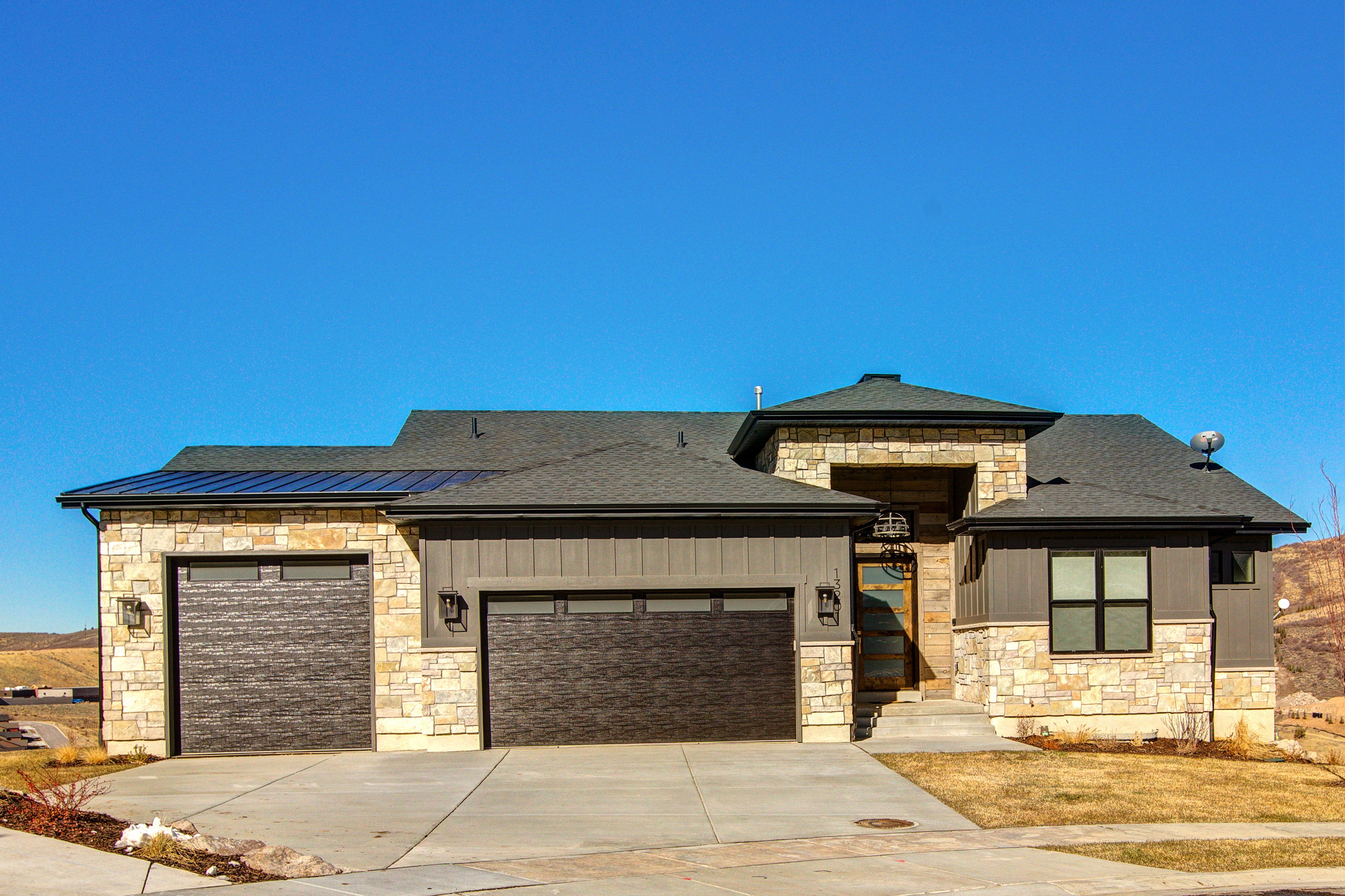 Modern ranch-style residence featuring a stone and board-and-batten exterior