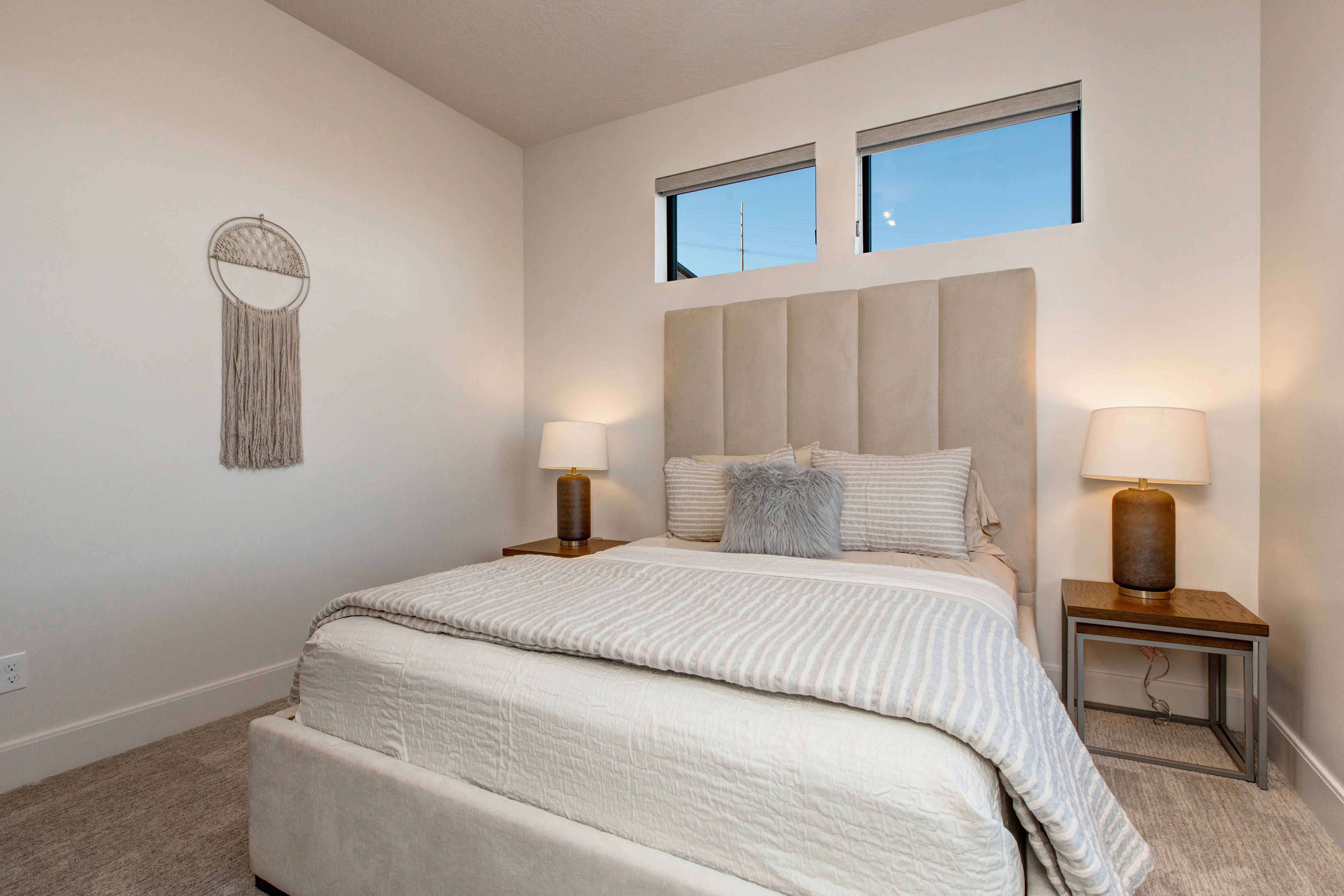 Upholstered bed frame with a vertical channel tufted headboard, flanked by wooden side tables with metallic bases