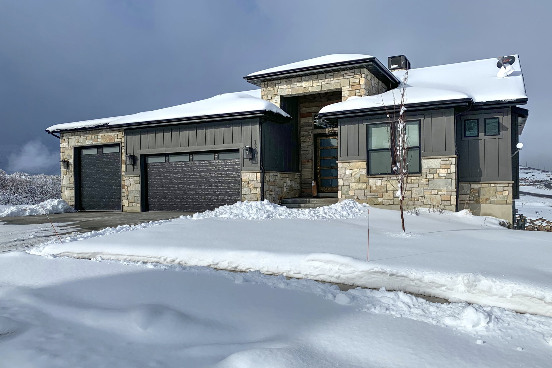 Contemporary residence featuring stone and vertical siding accents