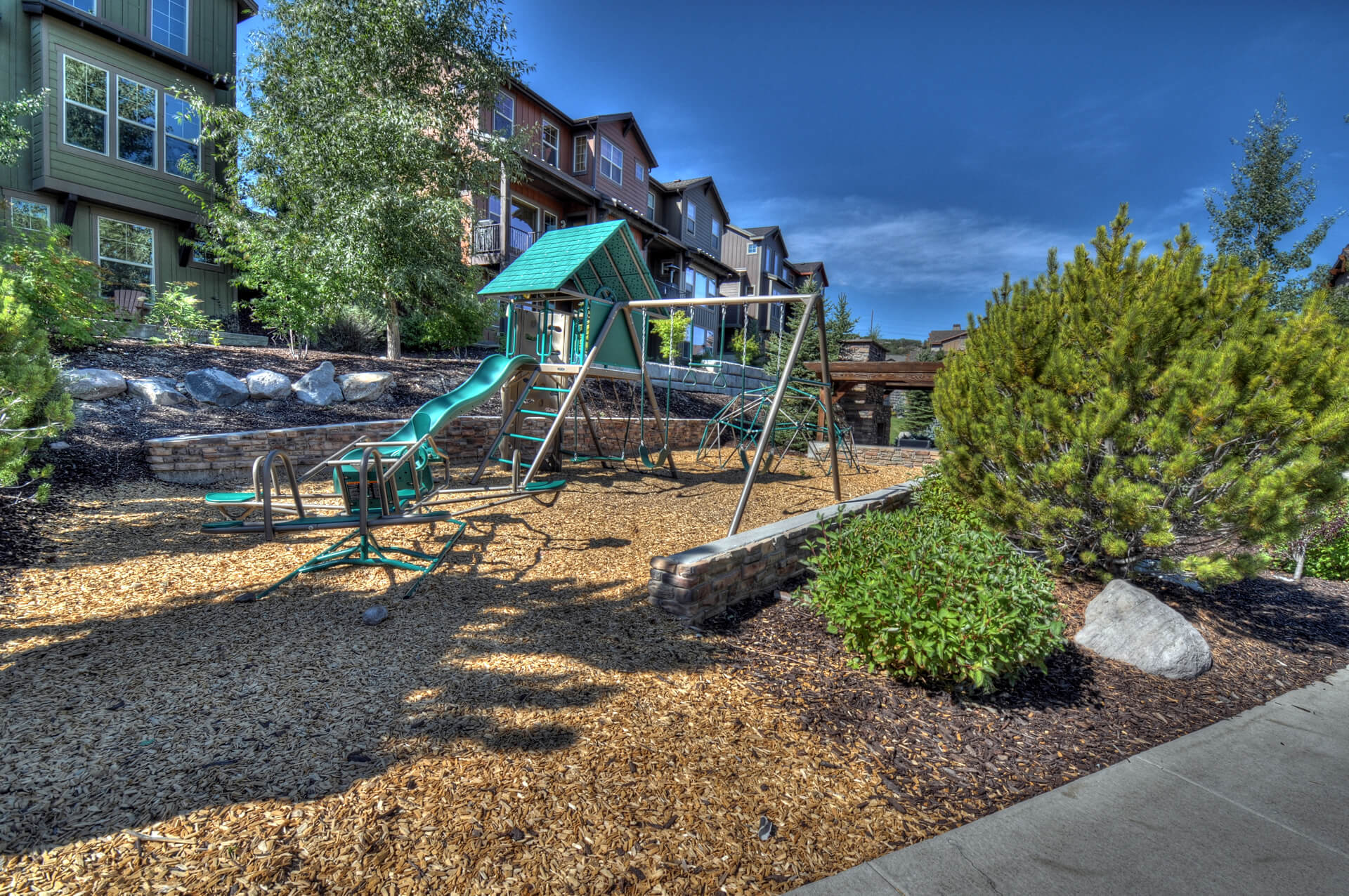 Outdoor play area featuring a swing set, slide, and seesaw
