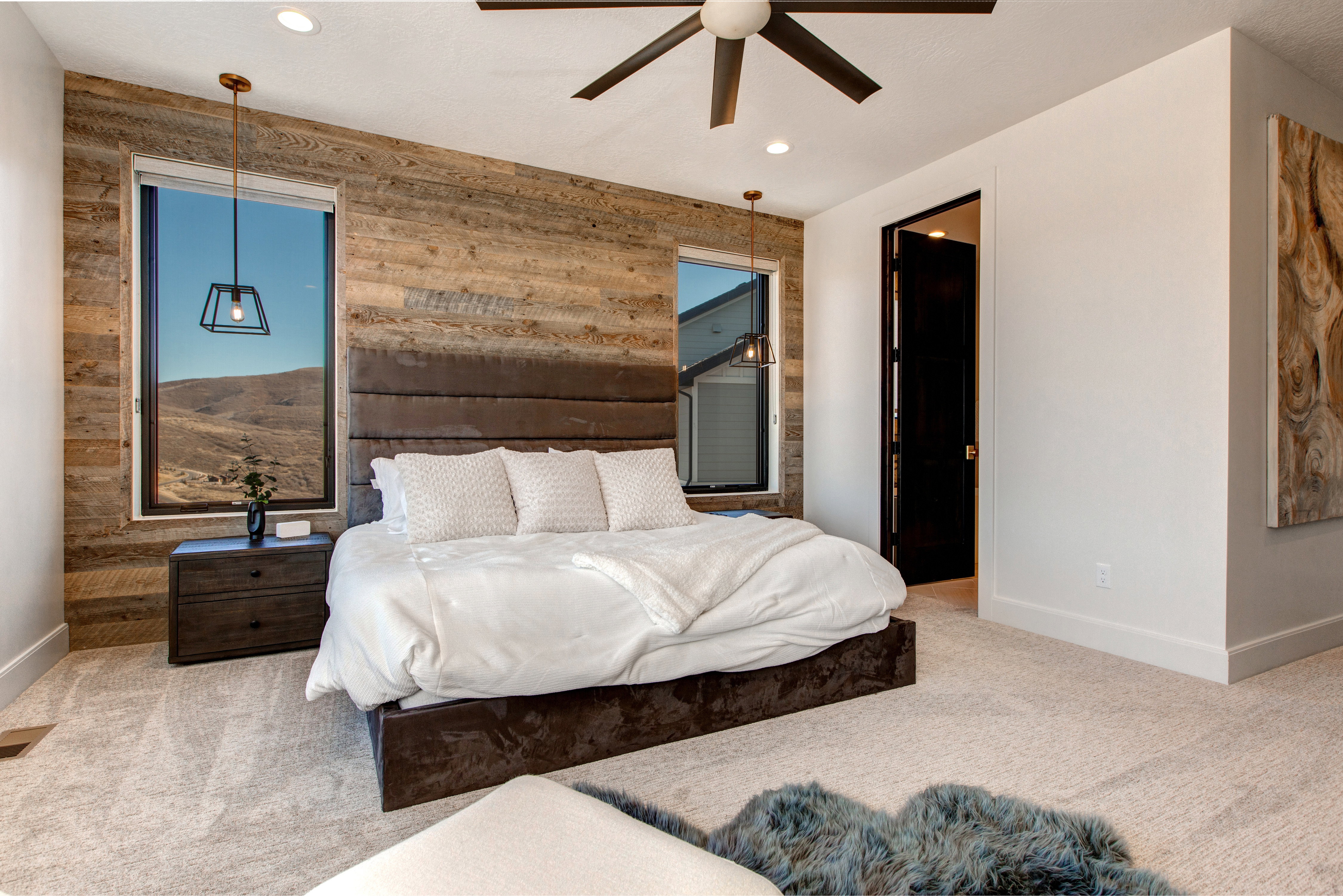 Bedroom featuring a wood-panel accent wall and plush carpeting