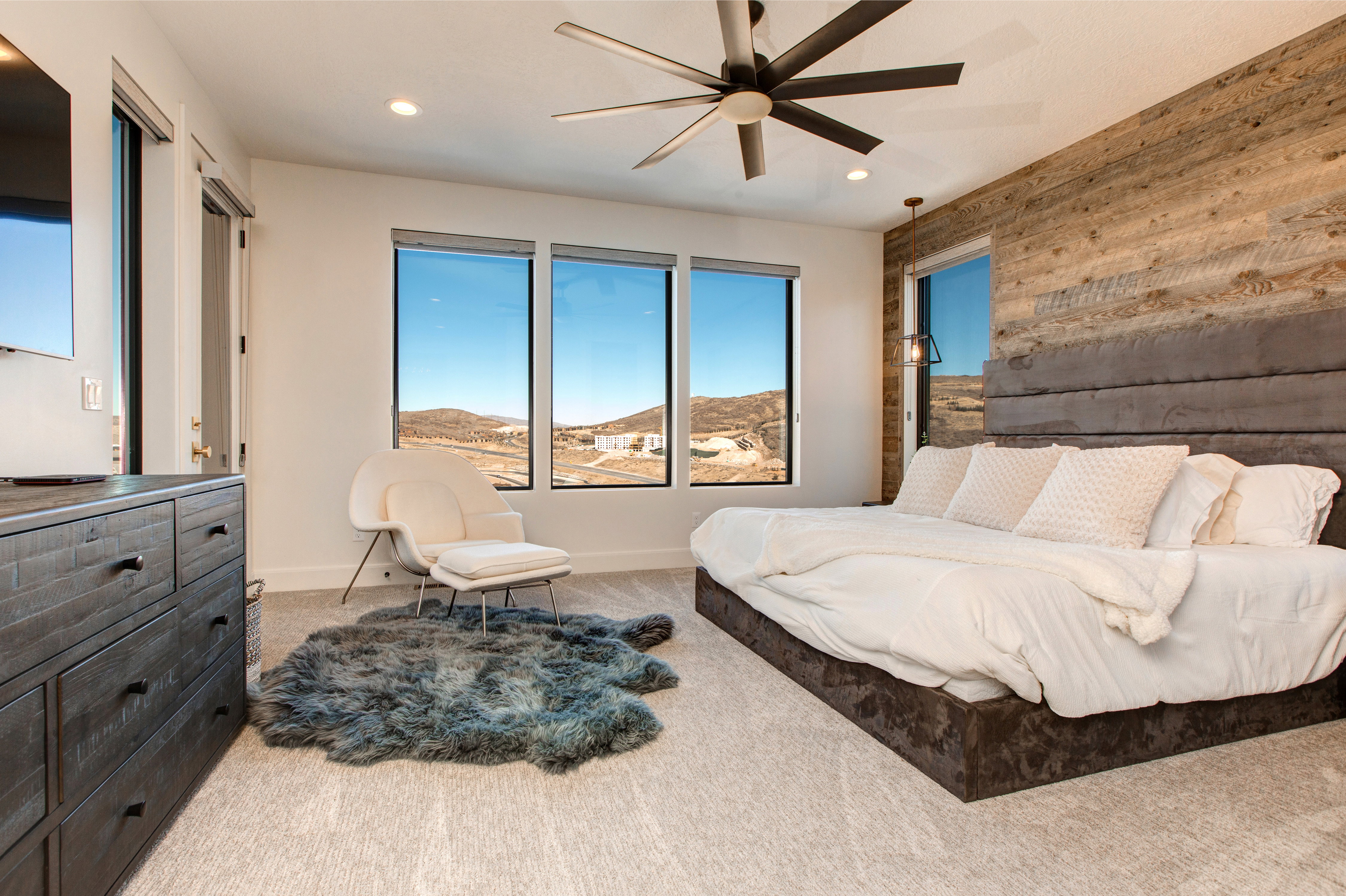 Bedroom featuring a wood-panel accent wall and recessed lighting
