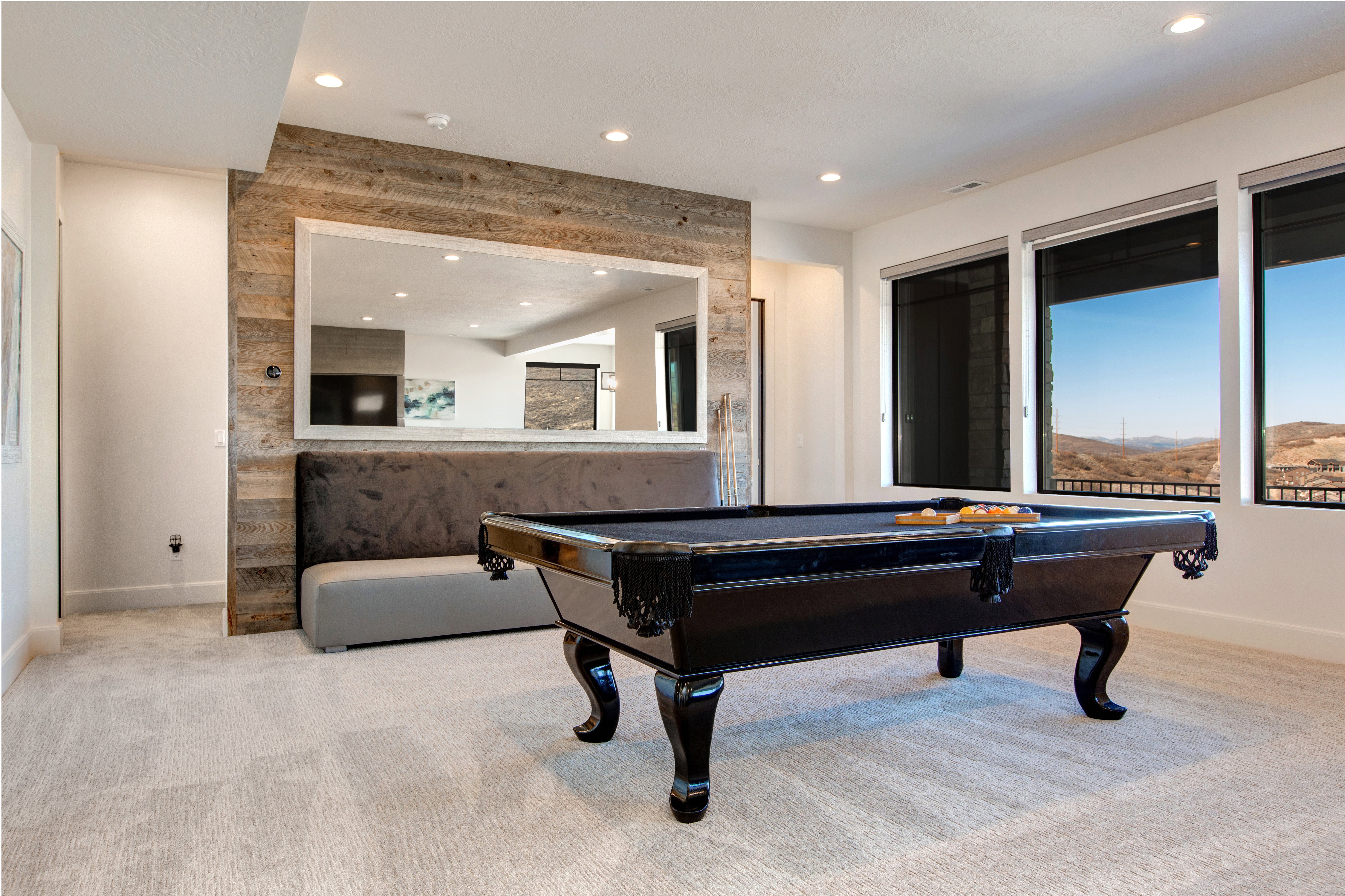 Recreation space featuring a wood-panel accent wall, recessed lighting, and expansive windows