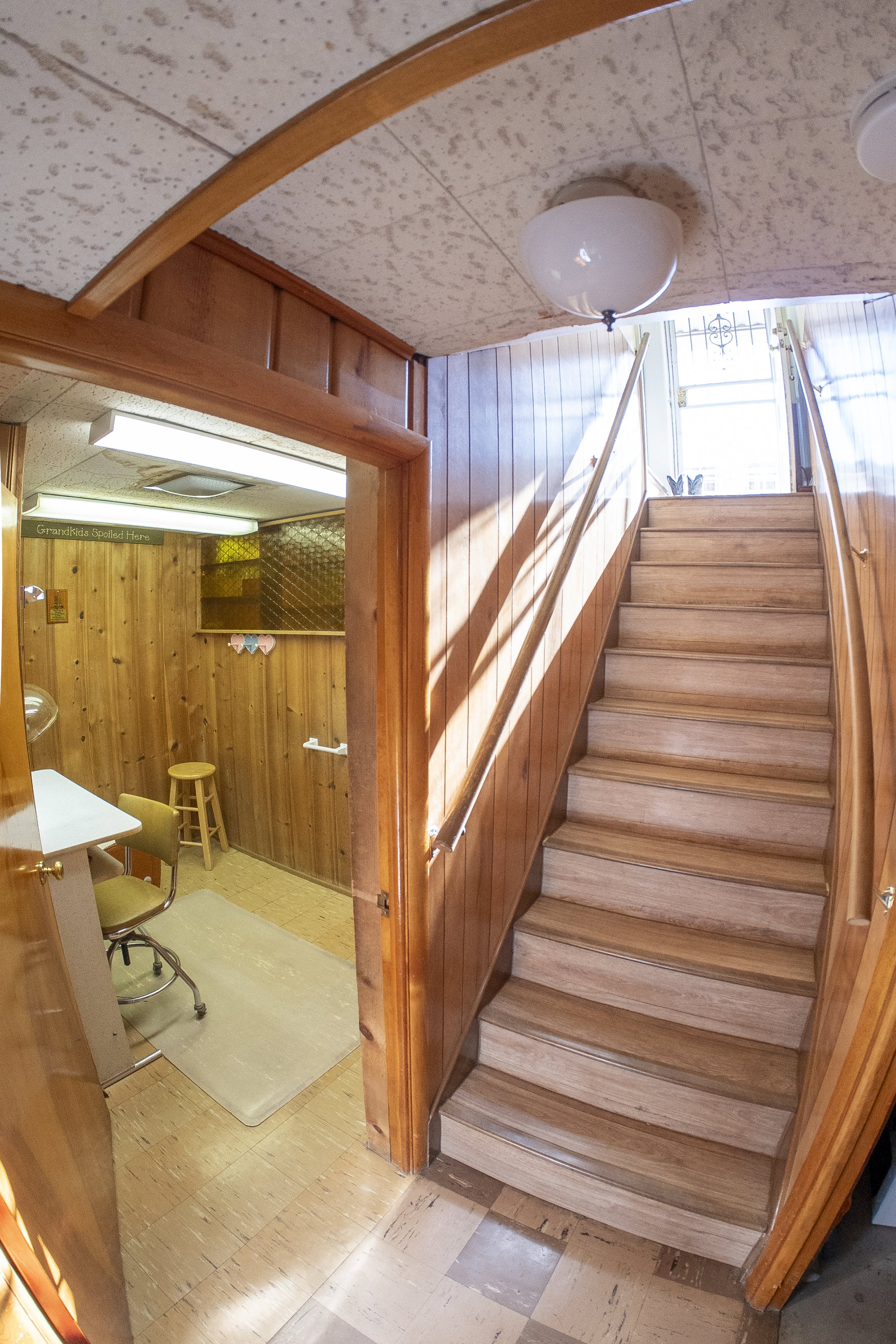 Wood-paneled staircase with a matching handrail