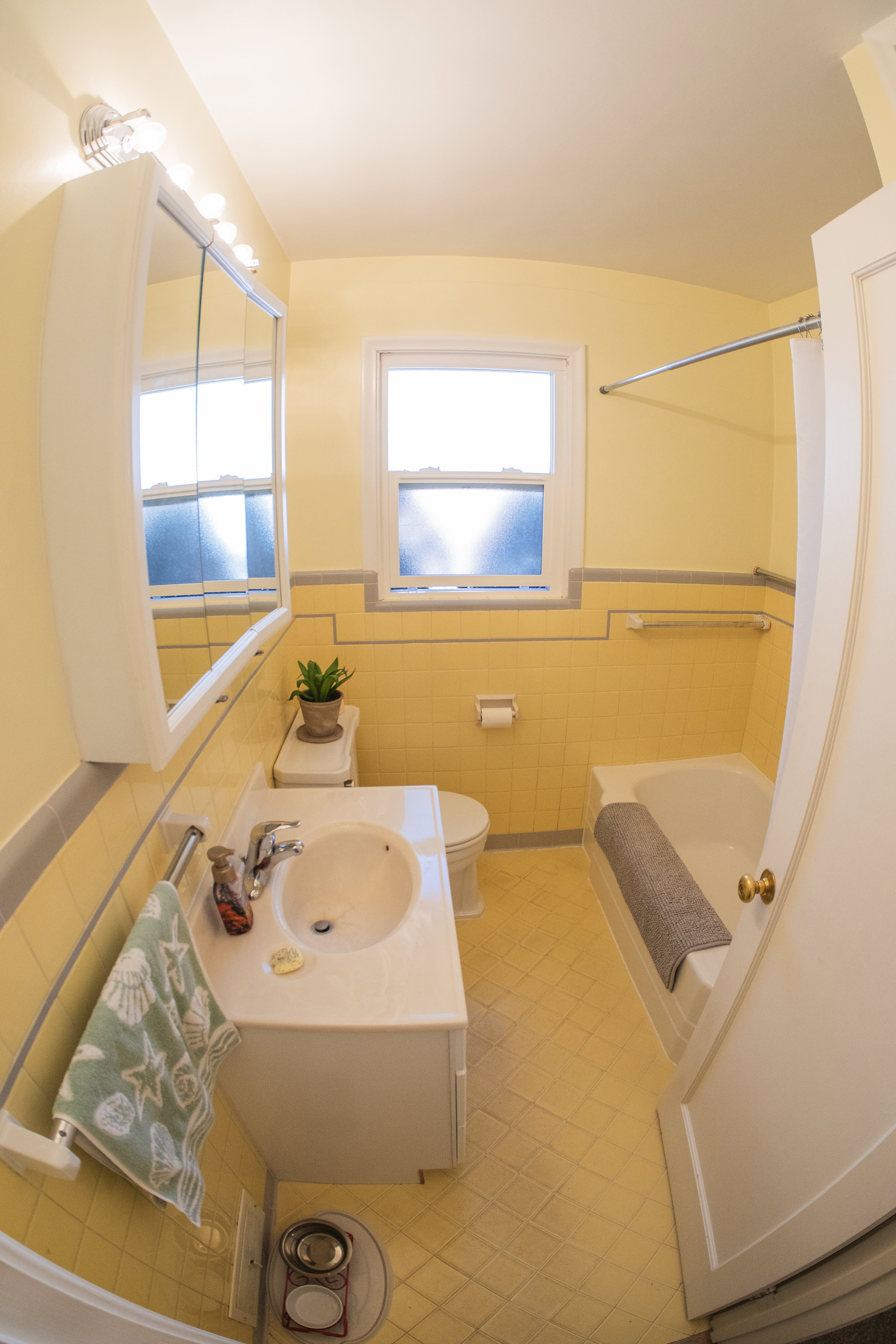 Bathroom featuring yellow wall tile and floor tile