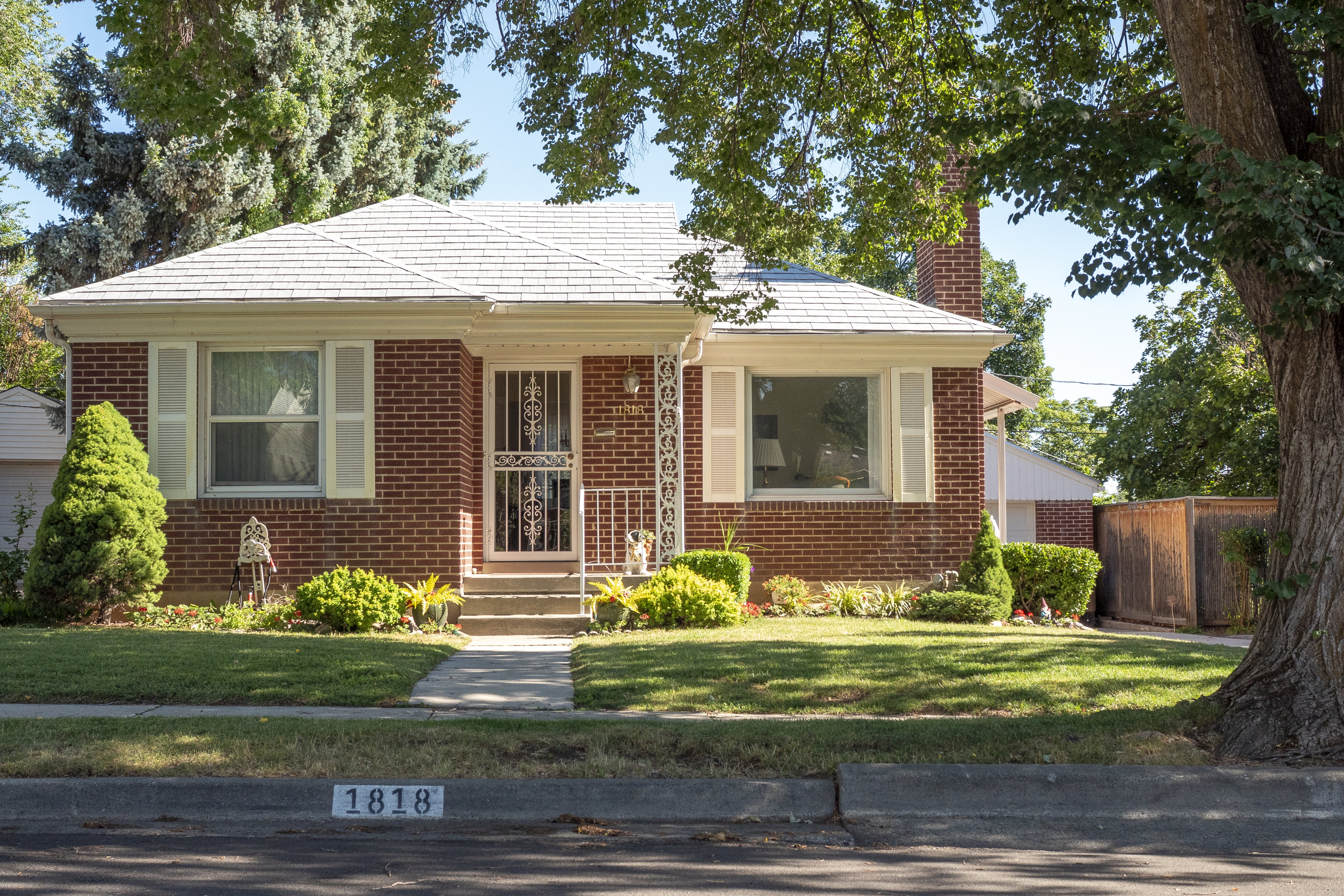 Brick exterior with white decorative shutters and a light-colored roof