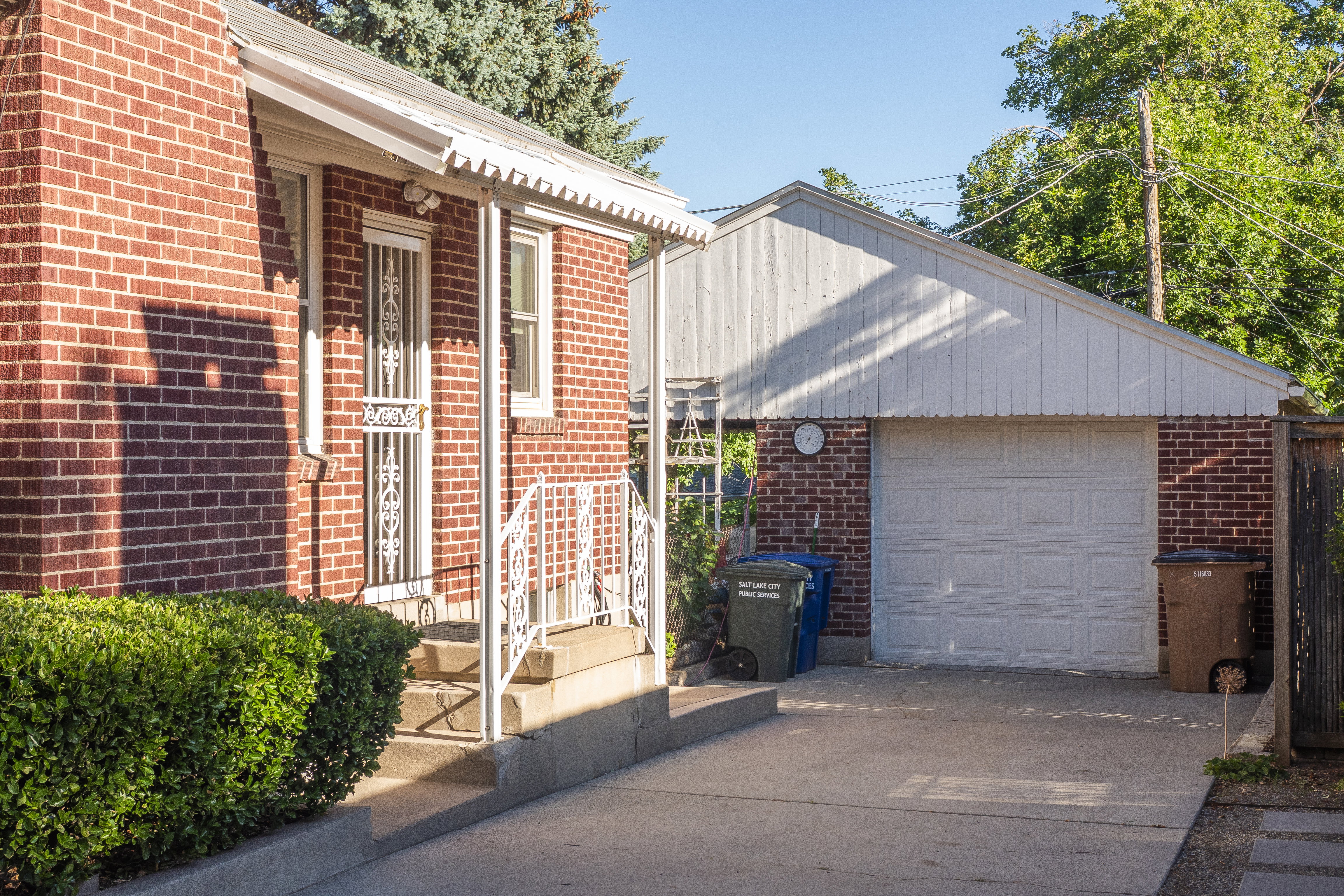 Red brick exterior featuring a covered porch entry with white railings