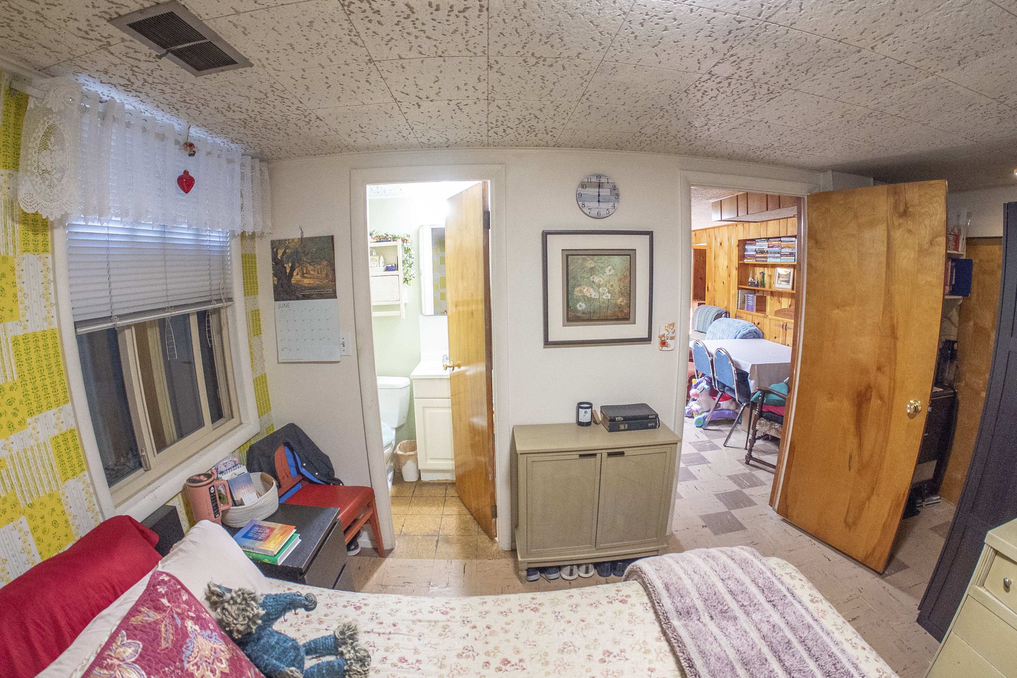 Interior room featuring a textured ceiling, a window with blinds, and a wood-panel door