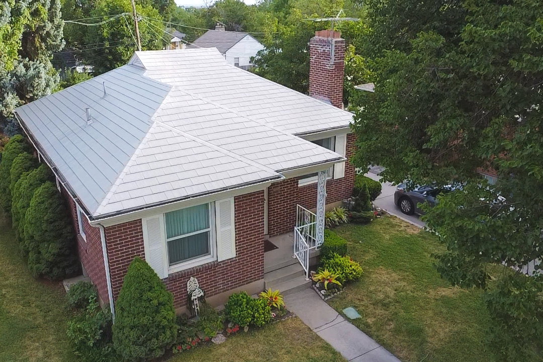 Brick exterior with white decorative shutters and a light-colored, multi-pitch roof