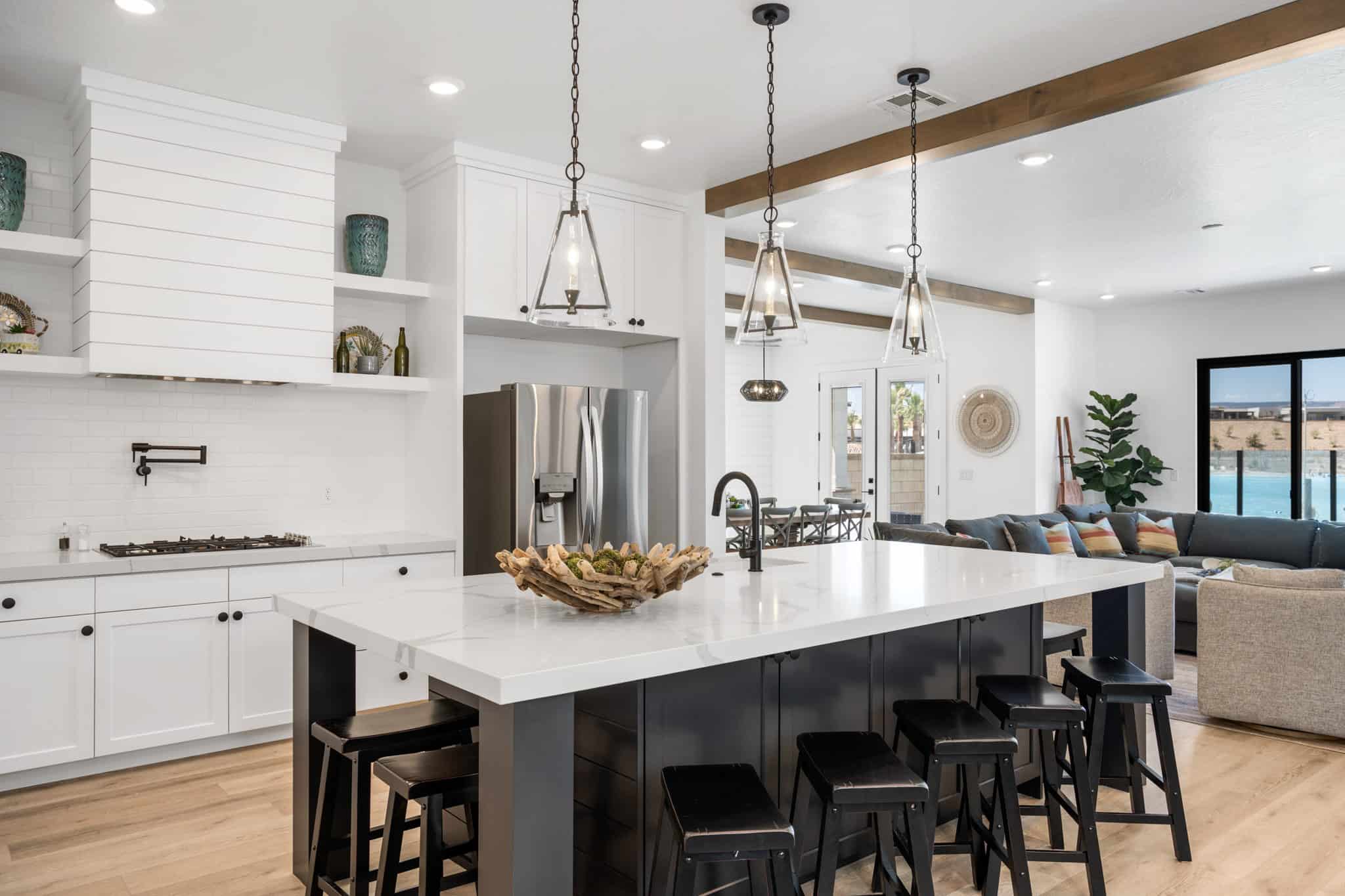 Open-concept kitchen with a large island featuring a white countertop and seating for four