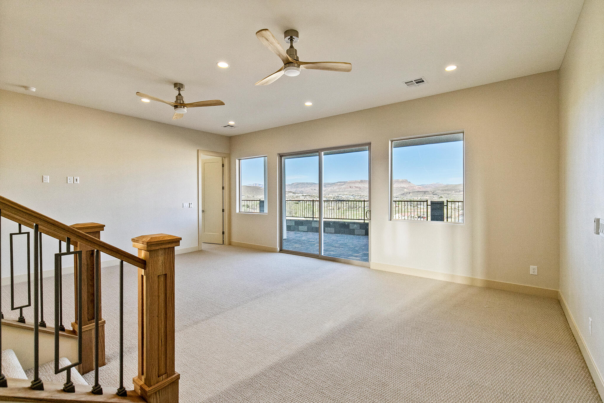 Spacious interior room with light-toned carpet flooring and neutral wall tones