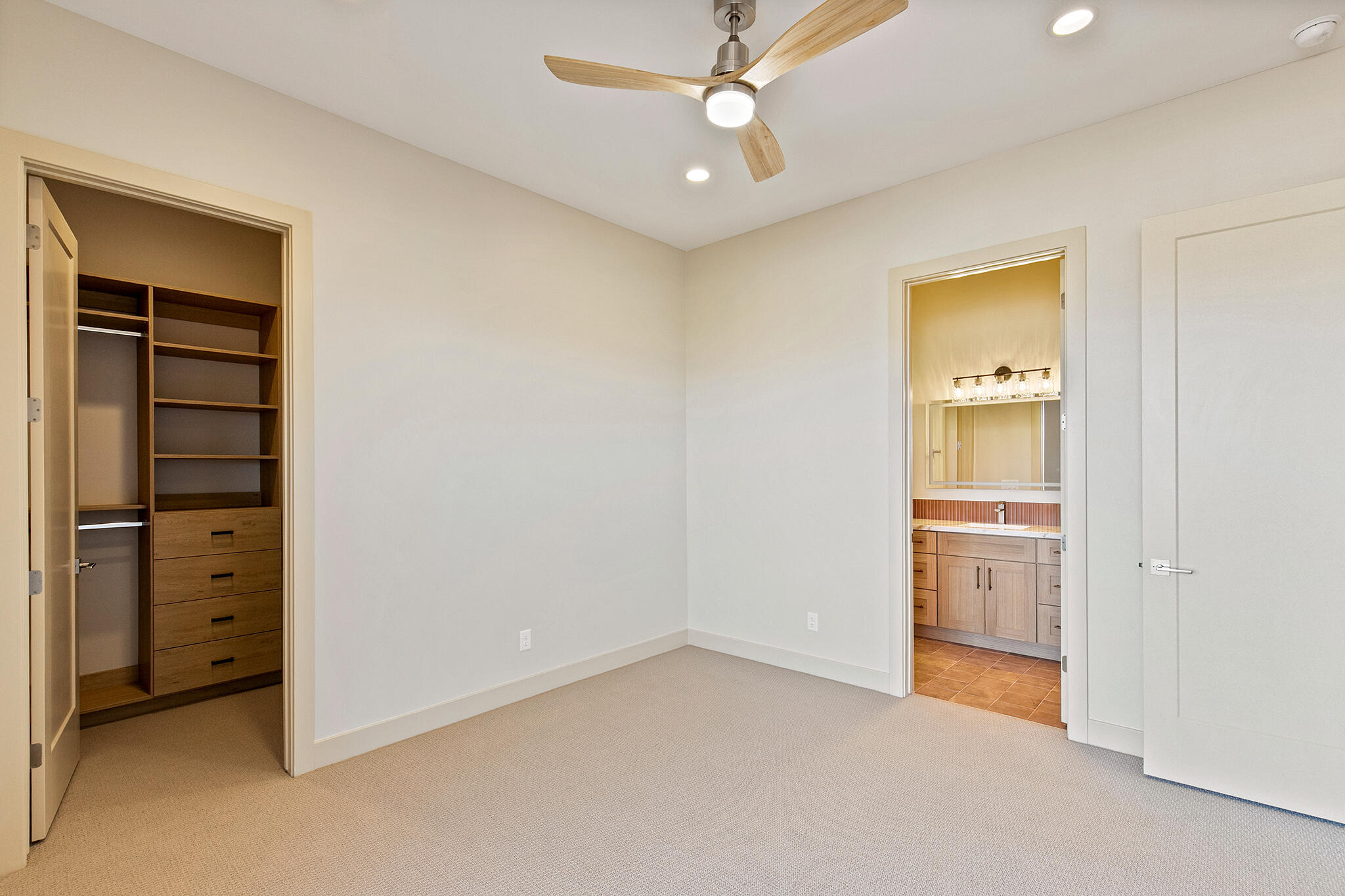 Neutral-toned room with plush carpeting and a modern ceiling fan with integrated lighting