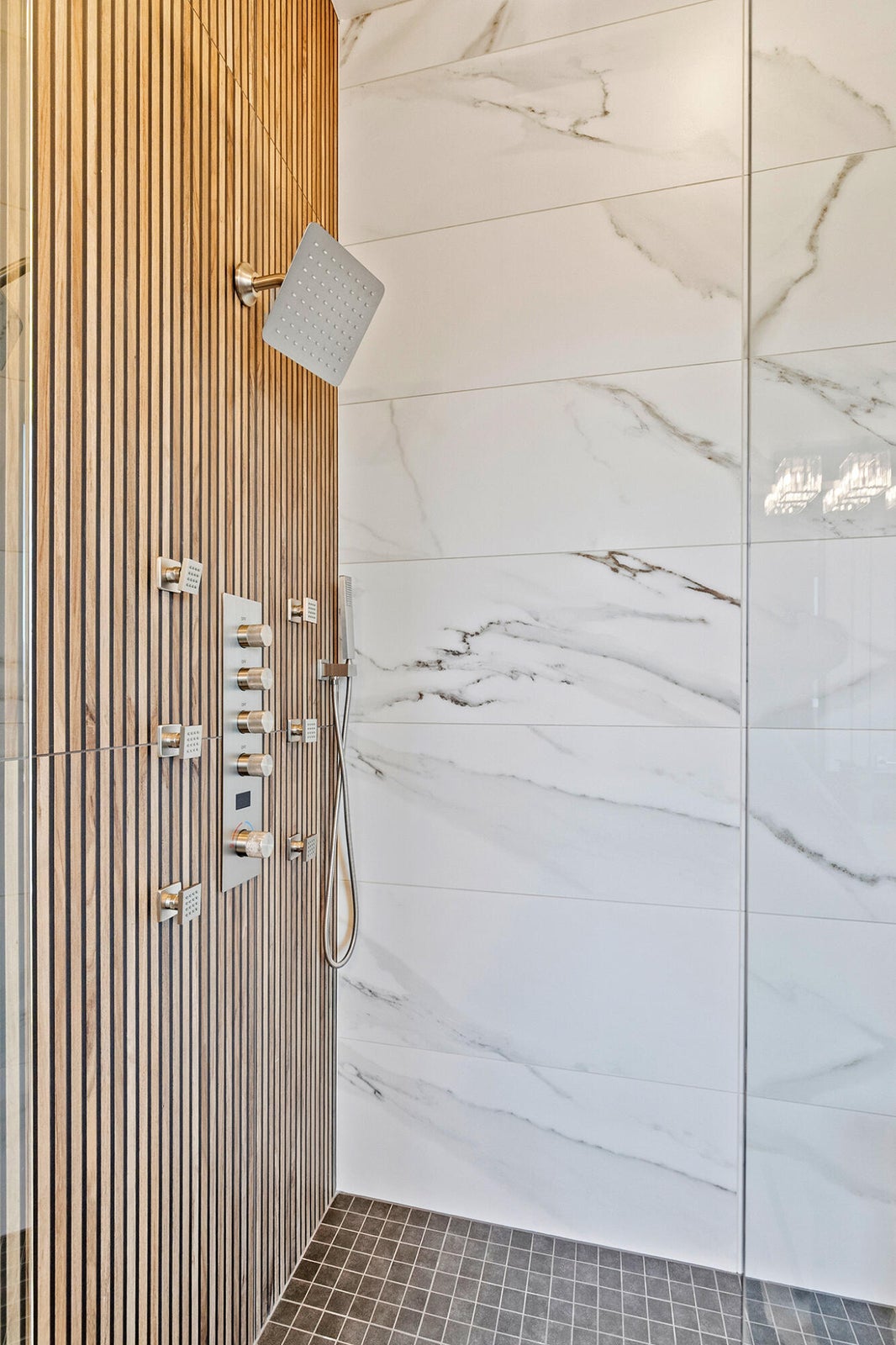 Contemporary shower enclosure featuring a wood-finish slat wall, square rainfall shower head, and an integrated multi-function shower panel with controls