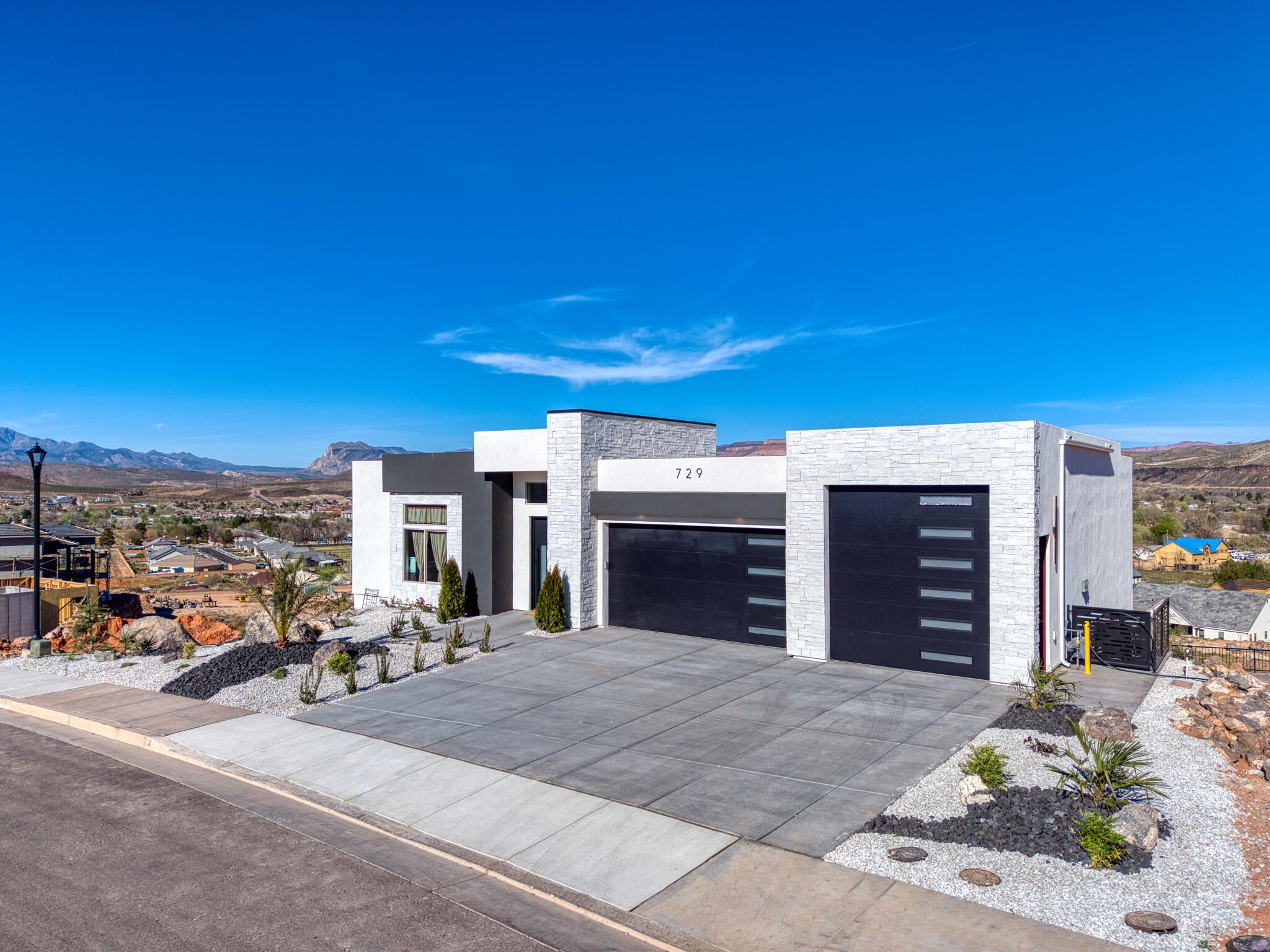 Modern architectural residence featuring a white stone facade and dark gray accents