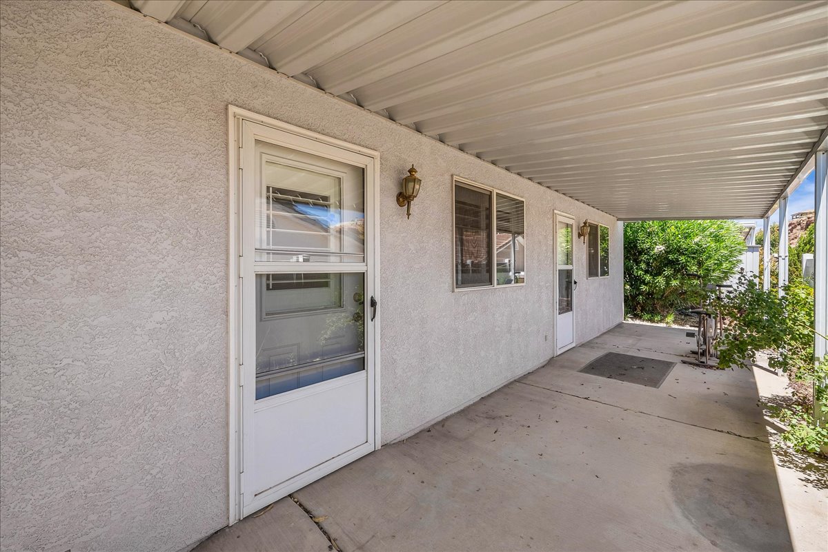 Covered patio featuring a stucco exterior and concrete flooring