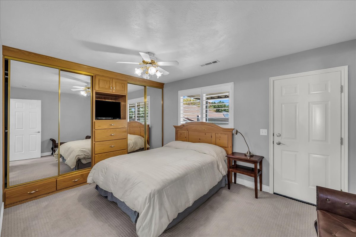 Built-in cabinetry with mirrored sliding doors, integrated dresser, and media niche