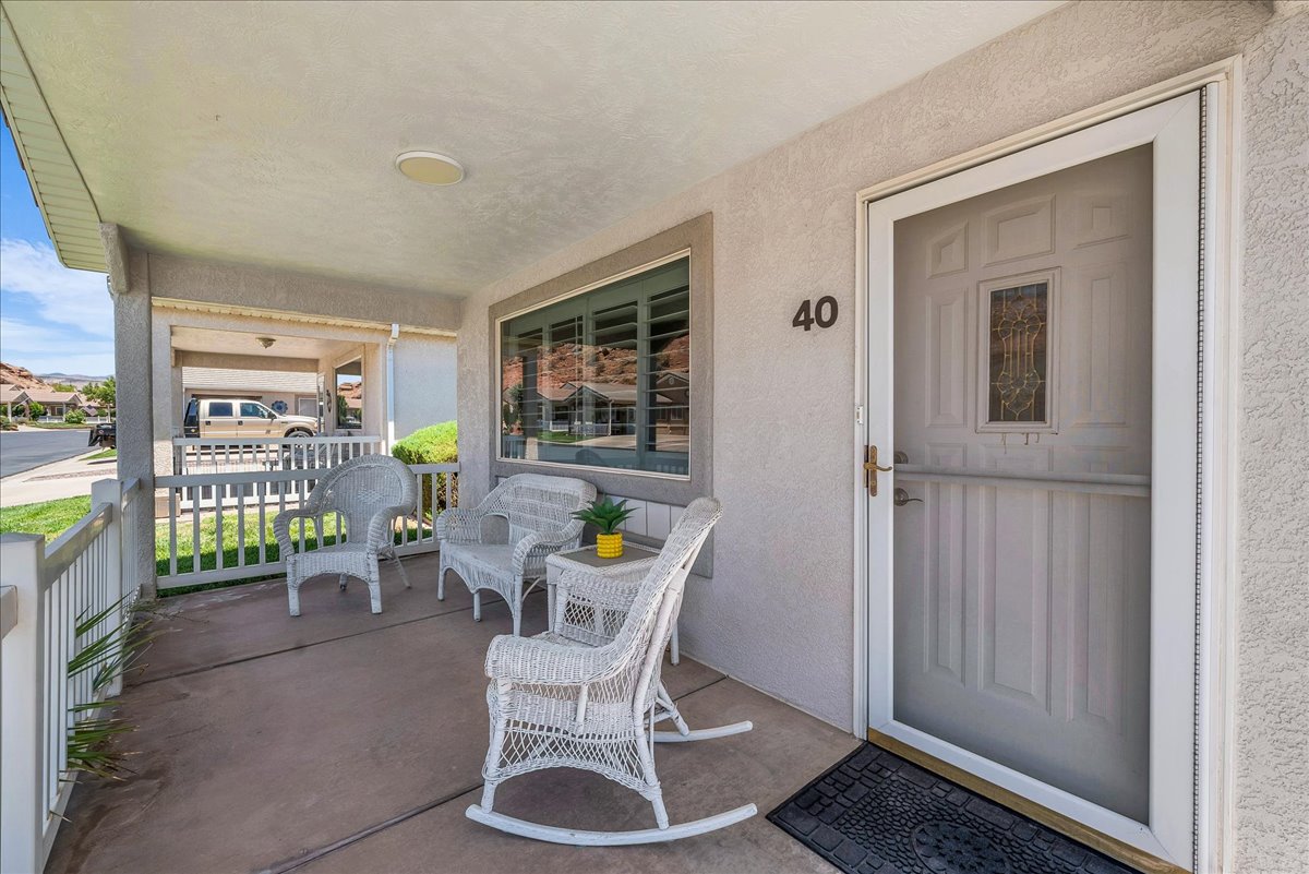 Inviting covered front porch with concrete flooring and a white railing
