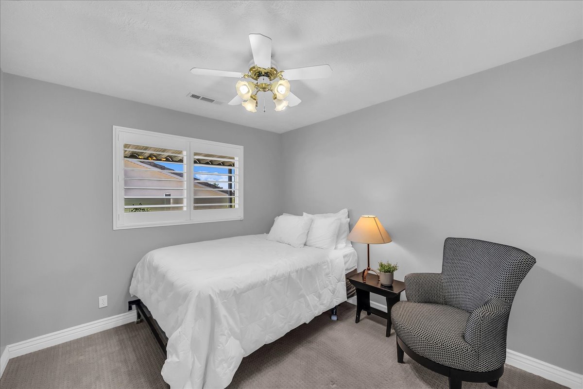 Bedroom featuring light gray walls, white baseboards, and neutral-toned carpet flooring