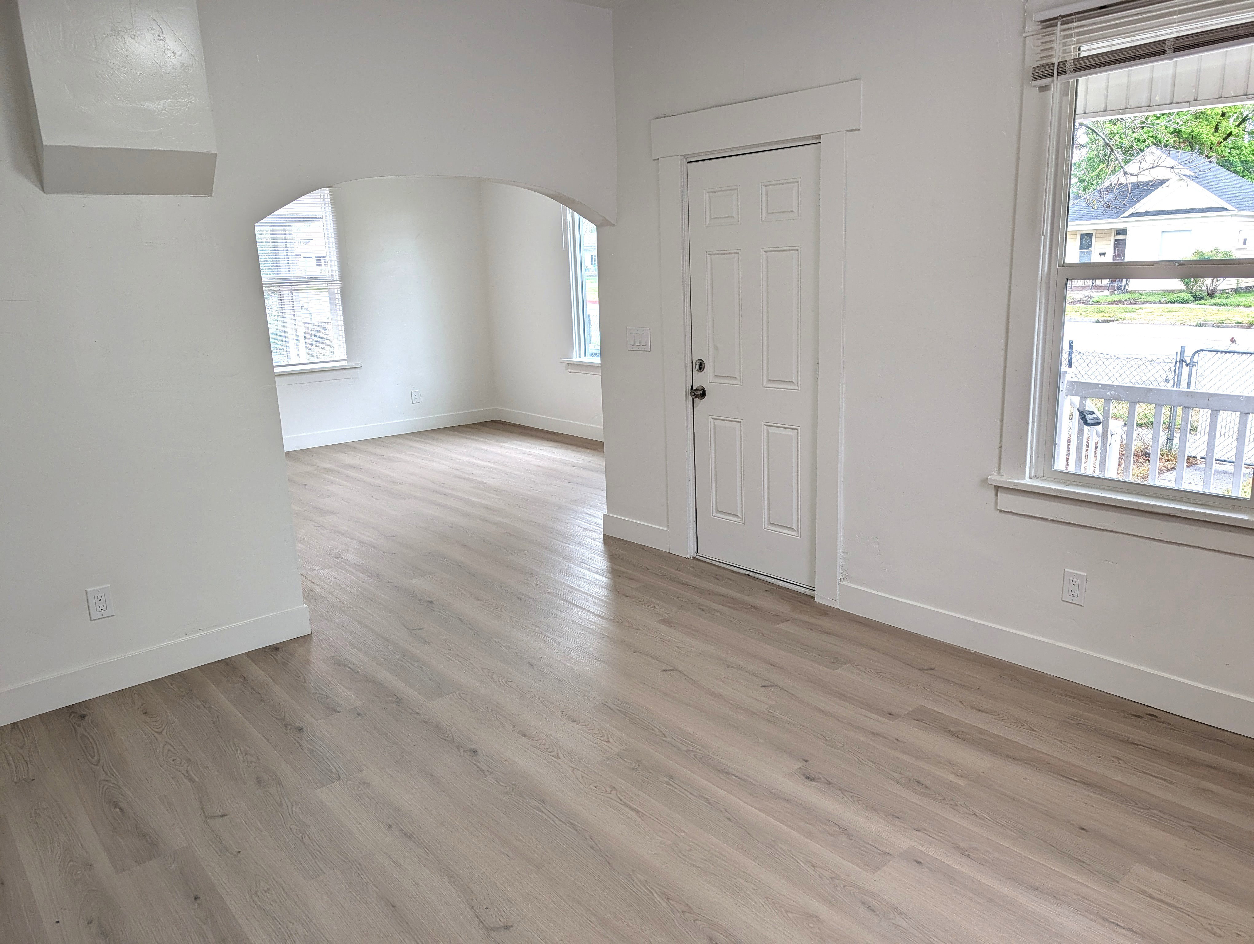 Light wood-finish flooring extending throughout, complemented by white baseboards and walls