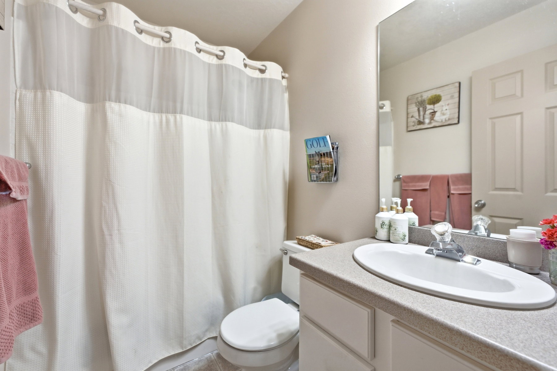 Additional Main floor Bathroom featuring an integrated sink vanity with a light-toned countertop, a large wall-mounted mirror, and a toilet