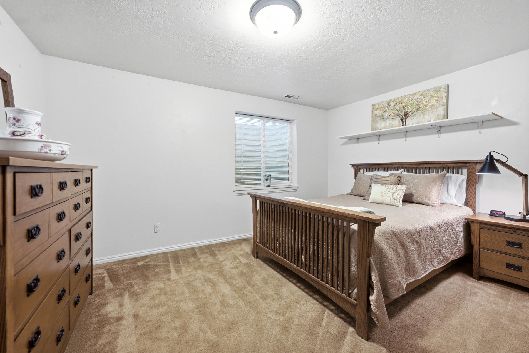Carpeted room featuring a window with horizontal blinds, white baseboards, and a semi-flush mount ceiling light fixture