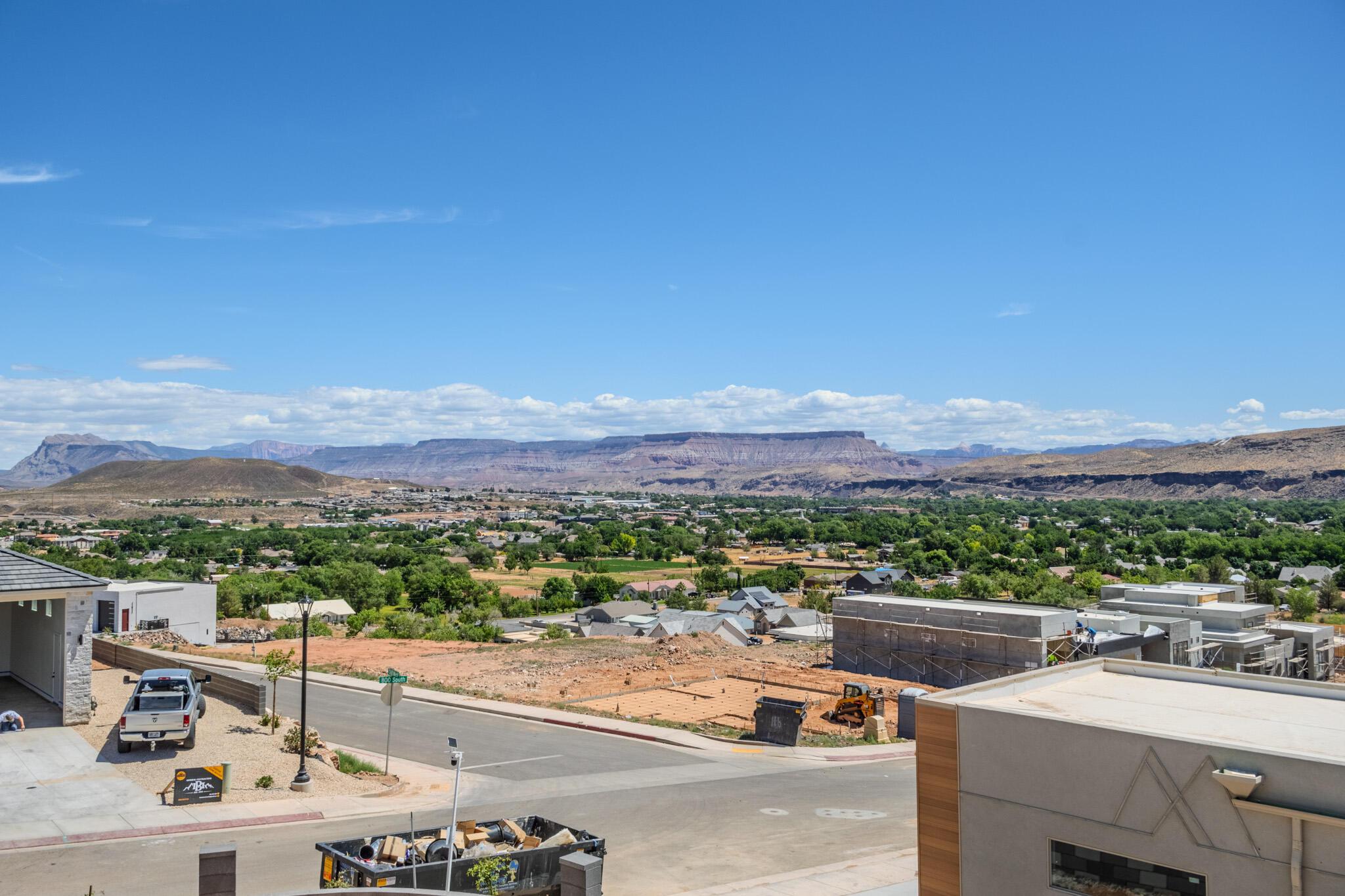 Expansive desert and mountain scenery with a verdant valley below
