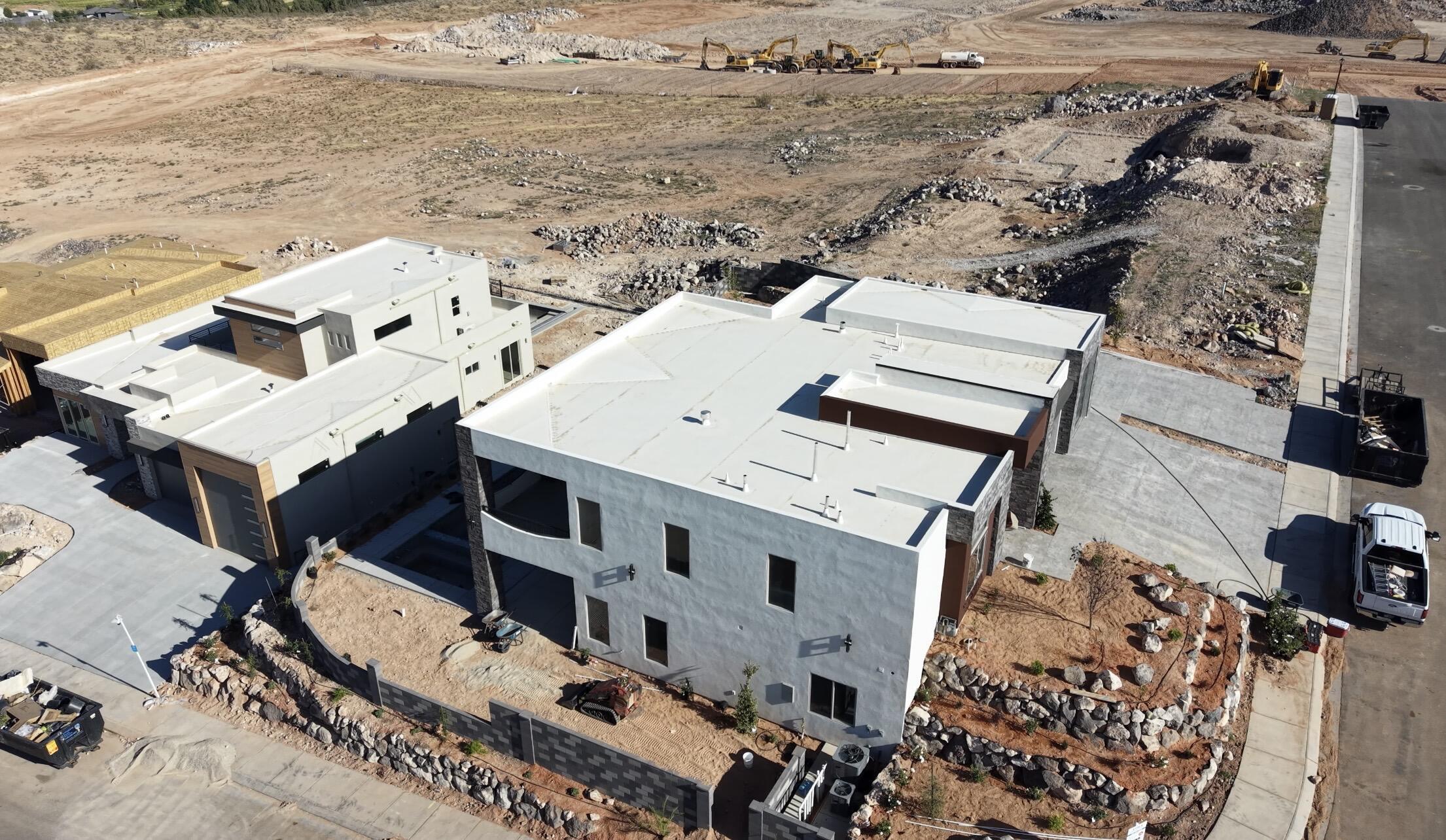 Contemporary white stucco exterior with multiple windows, a flat roofline, and an integrated two-car garage
