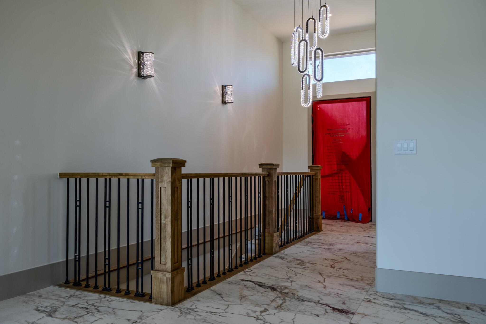 Elegant staircase landing featuring a natural wood railing with black metal balusters