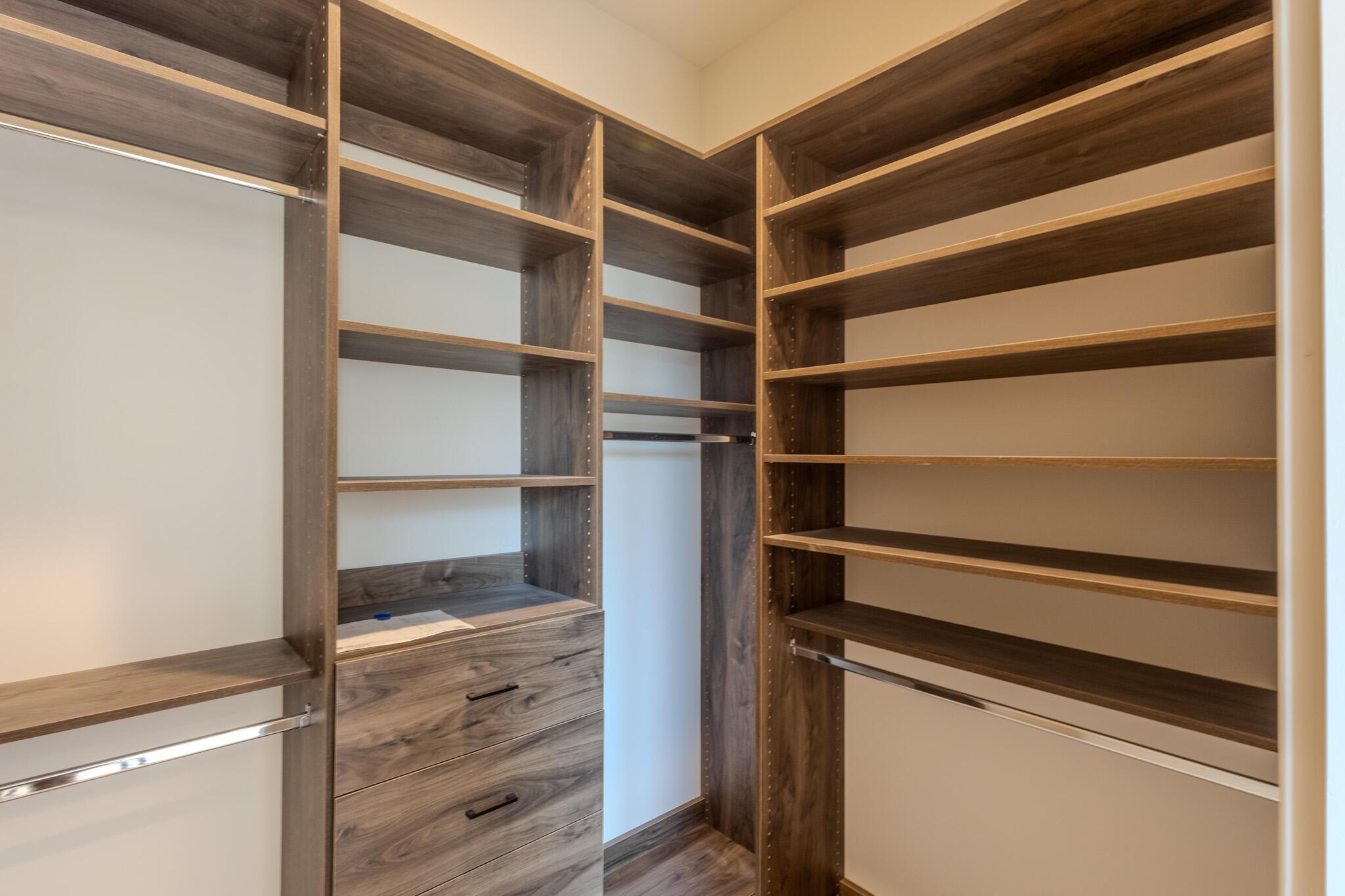 Custom closet system featuring wood-finish shelving and built-in drawers