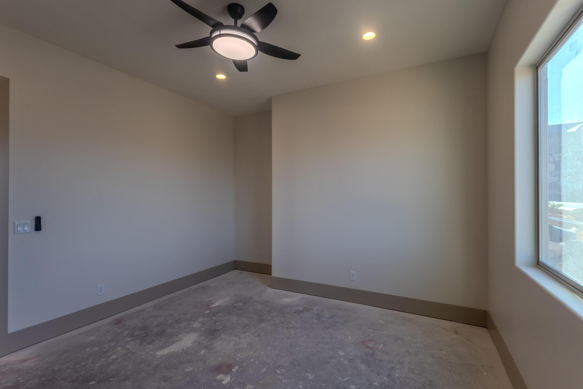 Interior space with a modern ceiling fan, recessed lighting, and a large window
