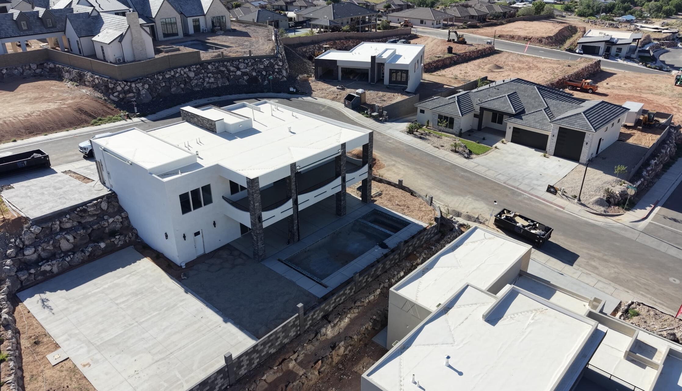 Modern architectural design featuring white stucco exterior, flat roofline, and stone-clad columns