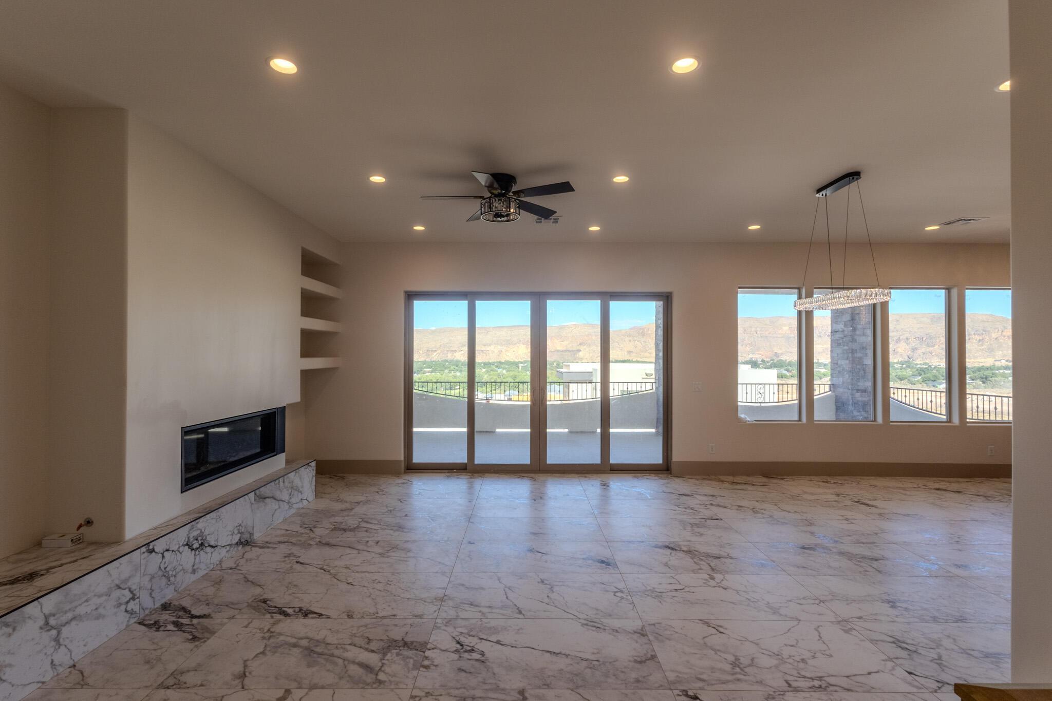 Spacious room featuring marble-look tile flooring, a modern fireplace with a marble-look hearth, and built-in shelving