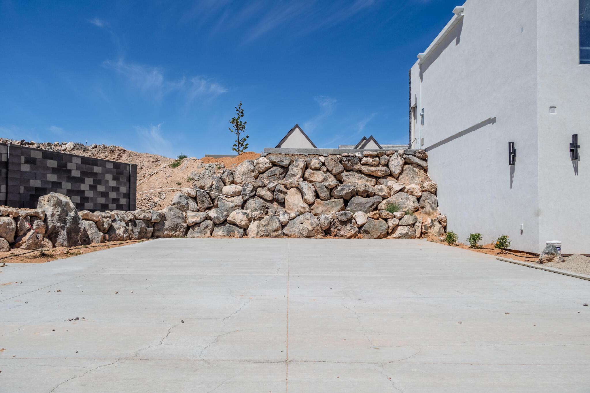 Concrete pad with a natural stone retaining wall