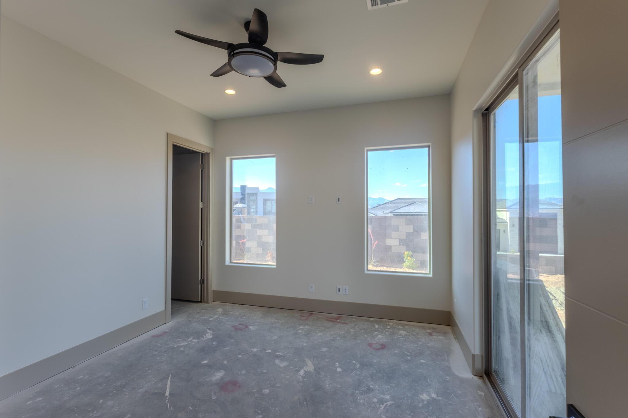 Spacious room featuring a ceiling fan with integrated lighting, recessed lighting, and two rectangular windows