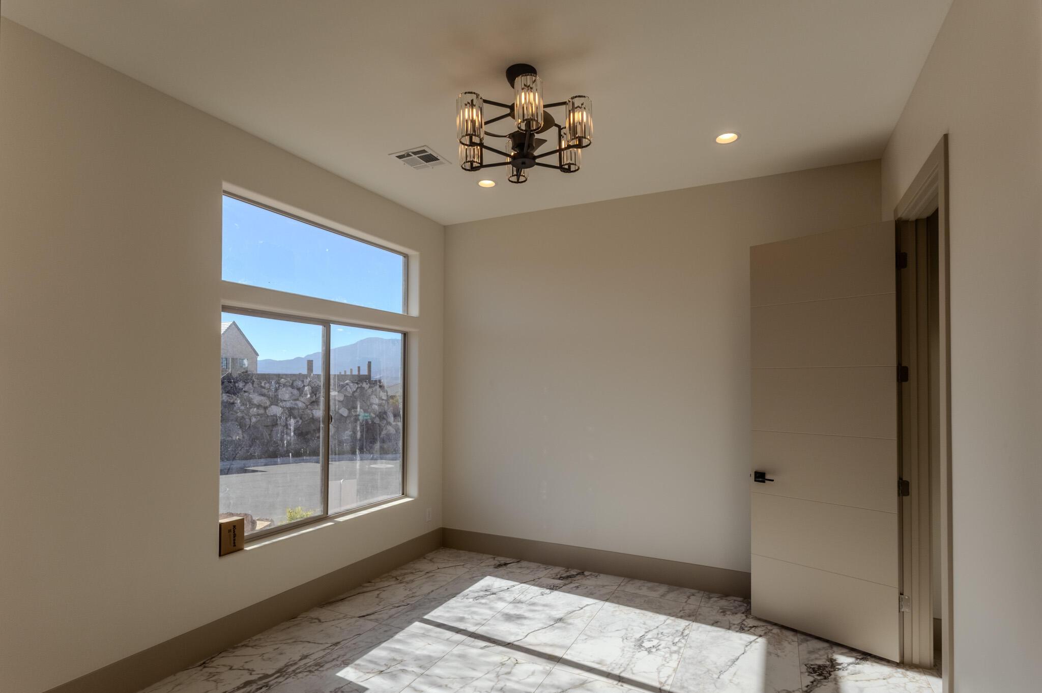 Room featuring large multi-pane windows, recessed lighting, and a contemporary chandelier