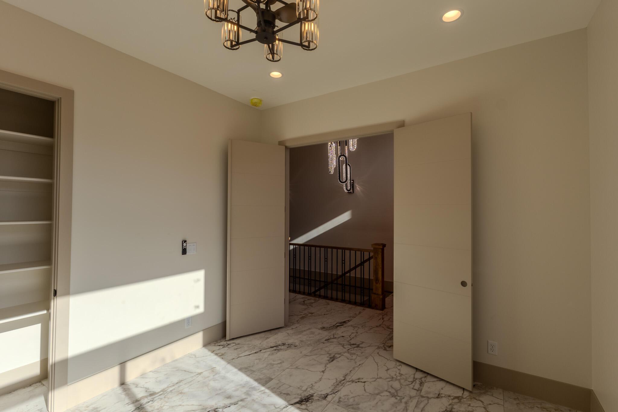Room featuring marble flooring, recessed lighting, and a contemporary chandelier
