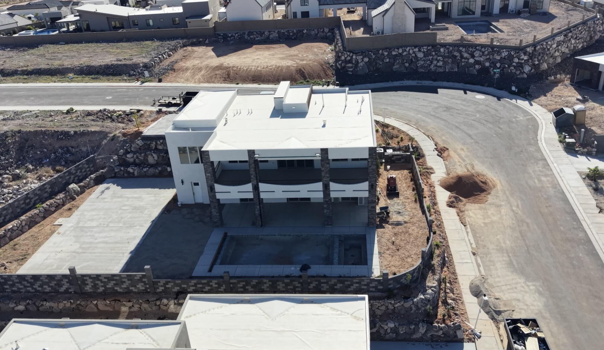 Modern multi-level residence featuring a flat roof and a concrete patio