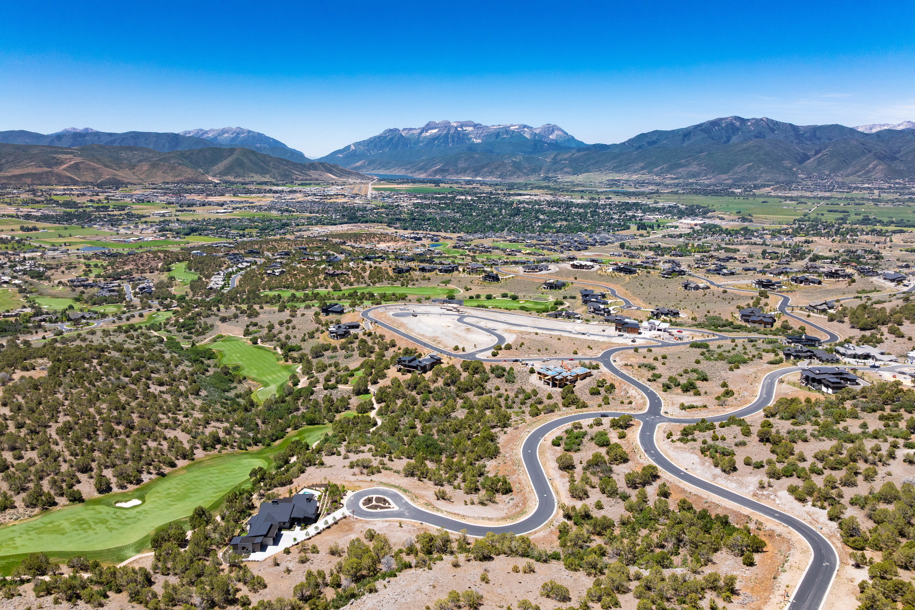 Expansive aerial panorama showcasing a mountainous landscape with a valley settlement