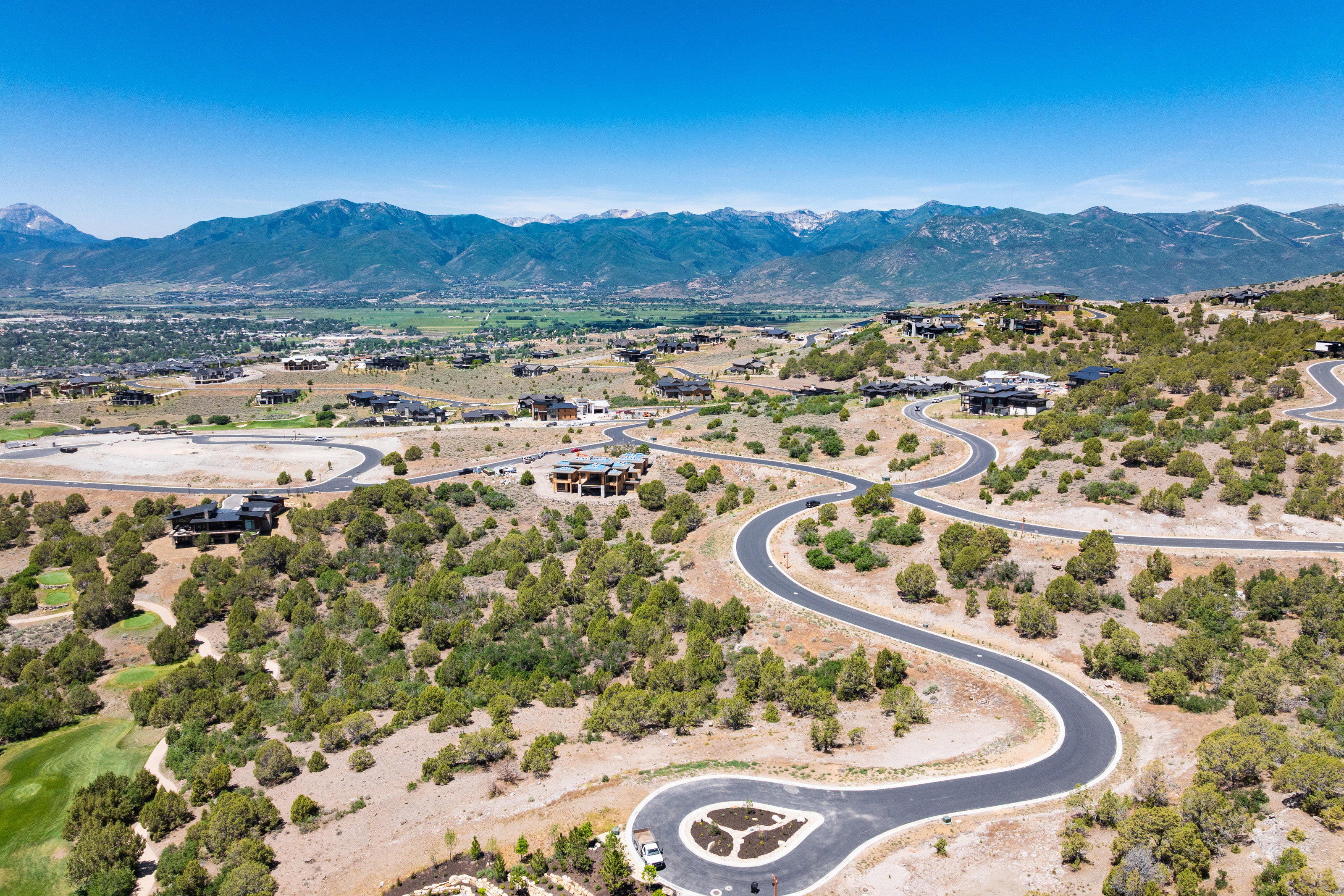 Expansive hillside community featuring winding paved roads and multiple contemporary residences