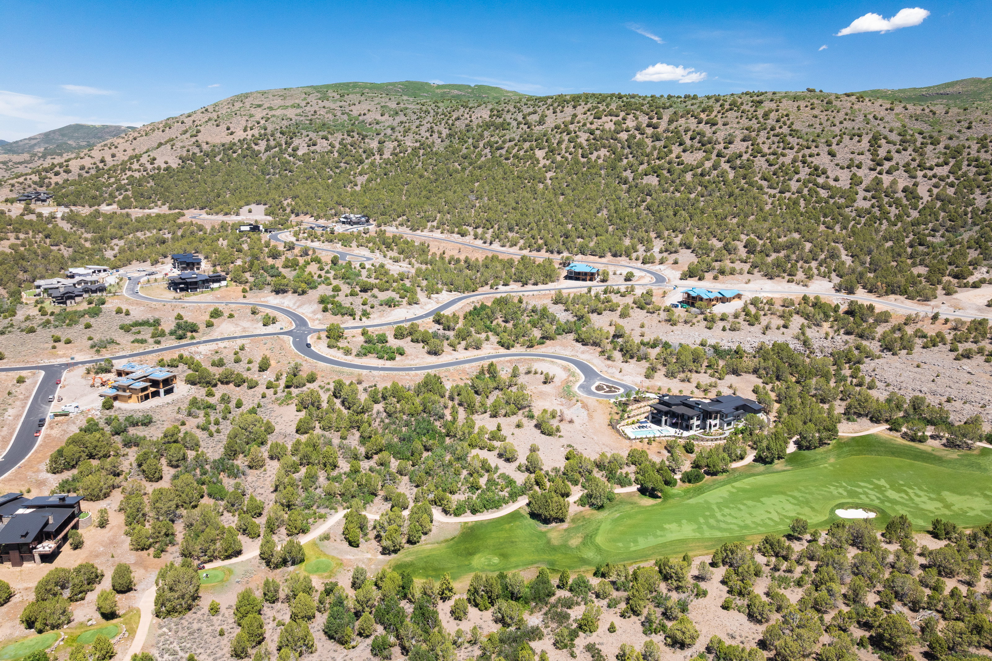 Aerial perspective showcasing multiple properties nestled within a natural, undulating landscape