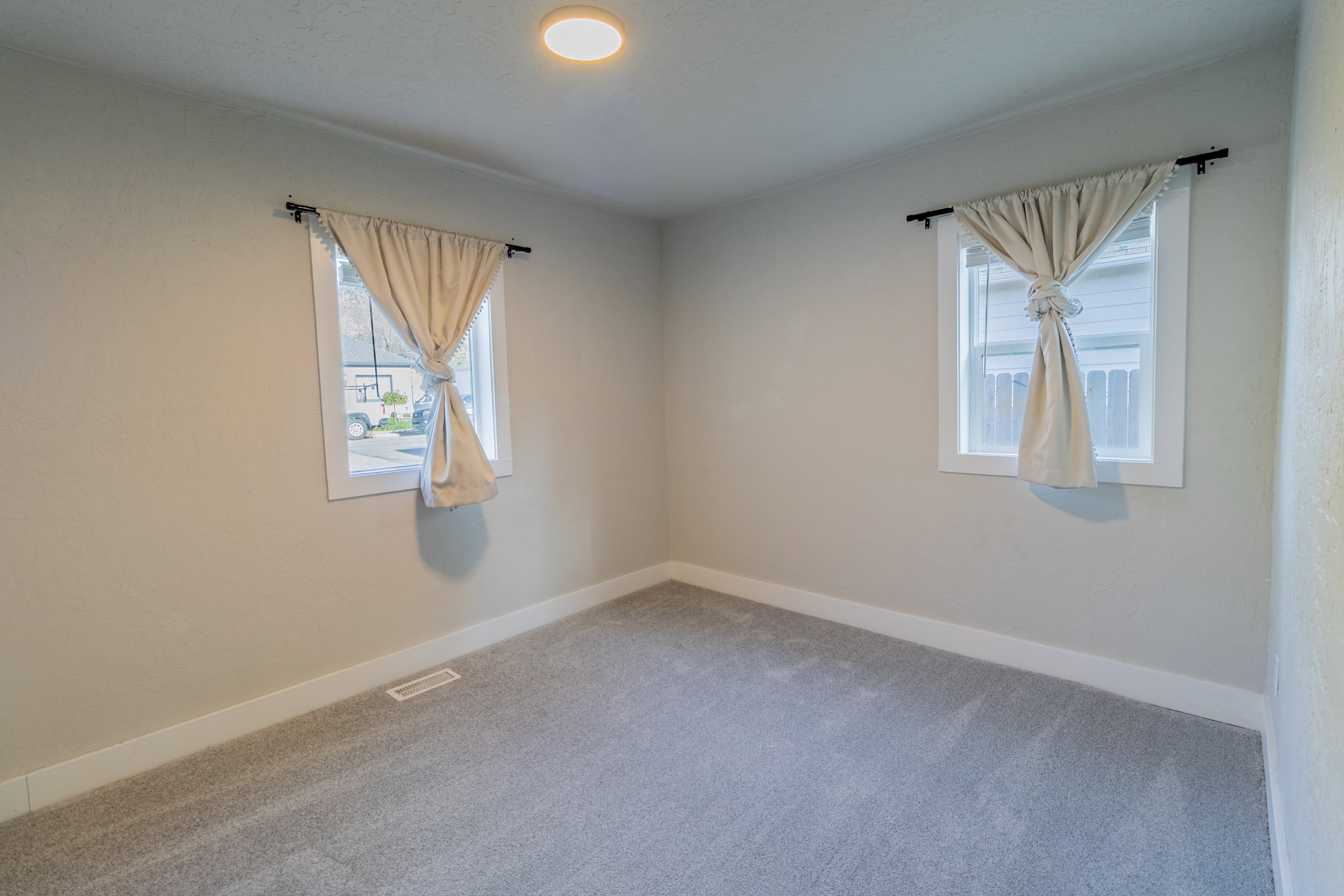 Room featuring light gray carpeting, neutral wall paint, and white trim