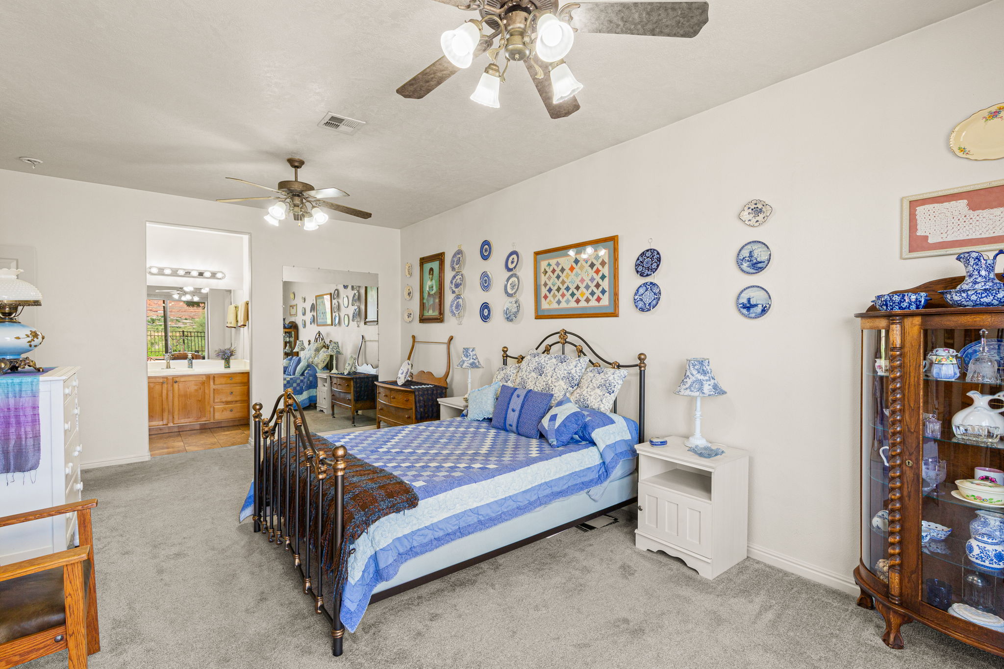 Carpeted bedroom featuring two ceiling fans with integrated lighting