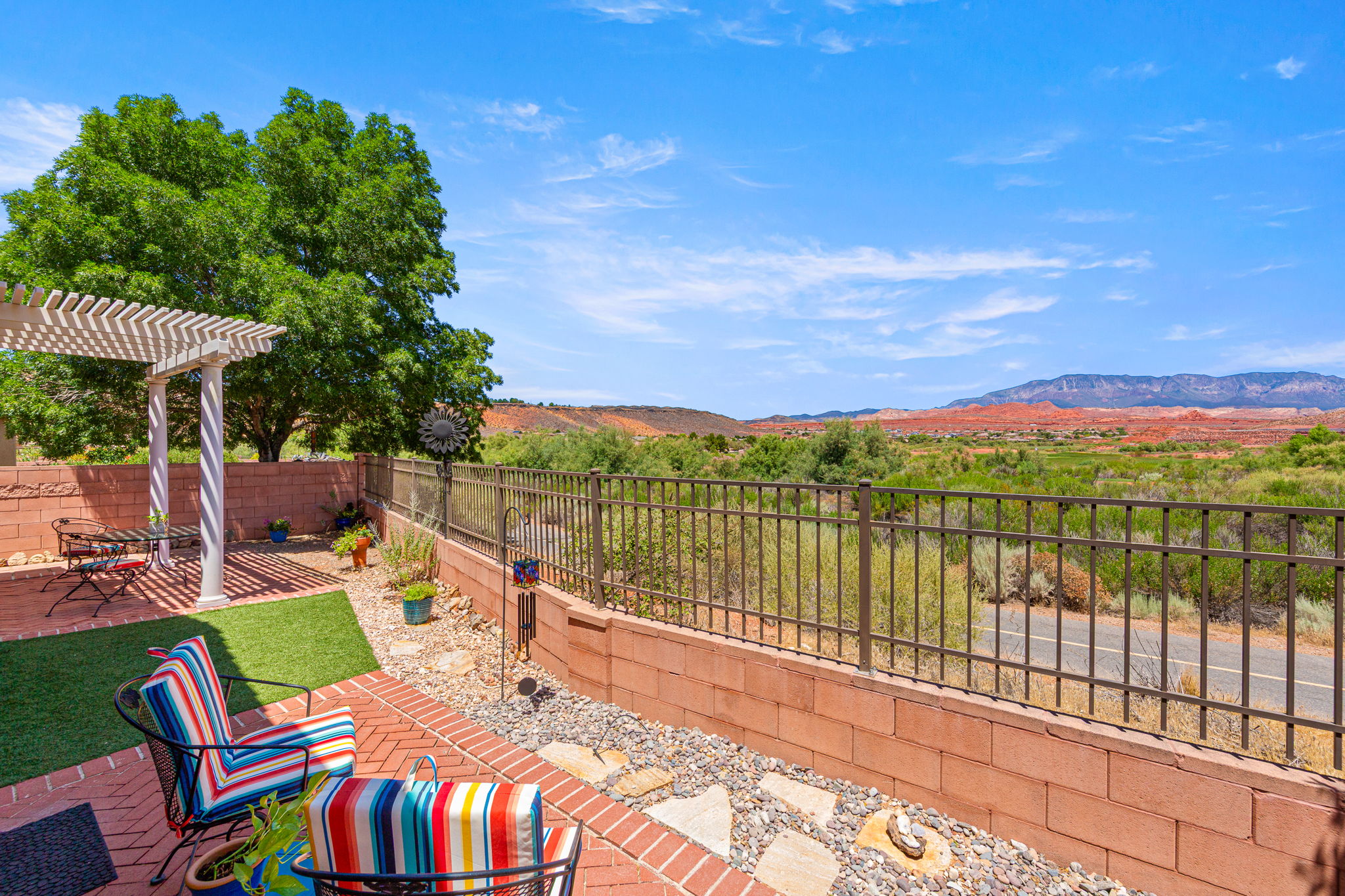 Outdoor patio with a brick paver surface and a white pergola